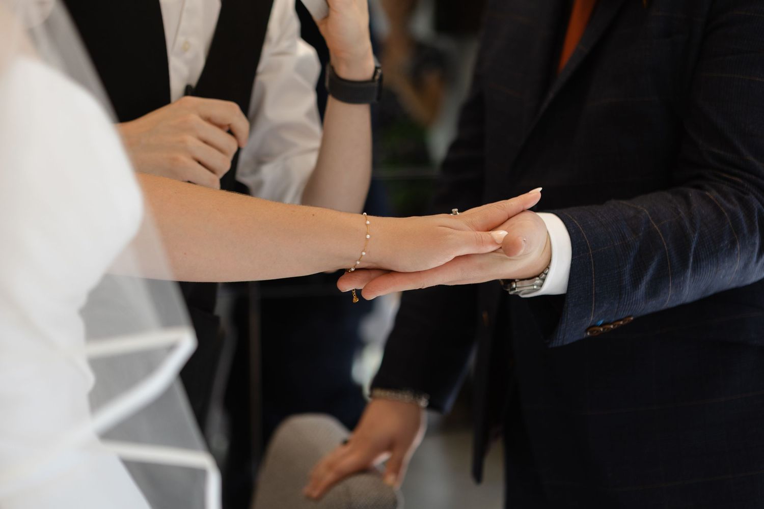 Close-up view of hands during a wedding ceremony exchange.