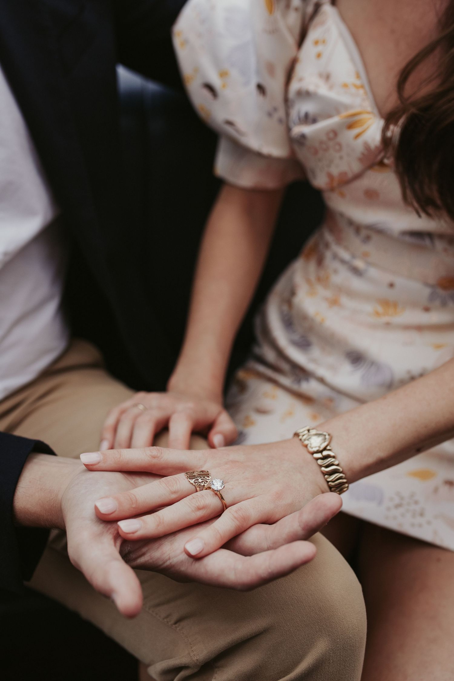 Une future mariée montre sa bague en posant sa main dans celle de son fiancé