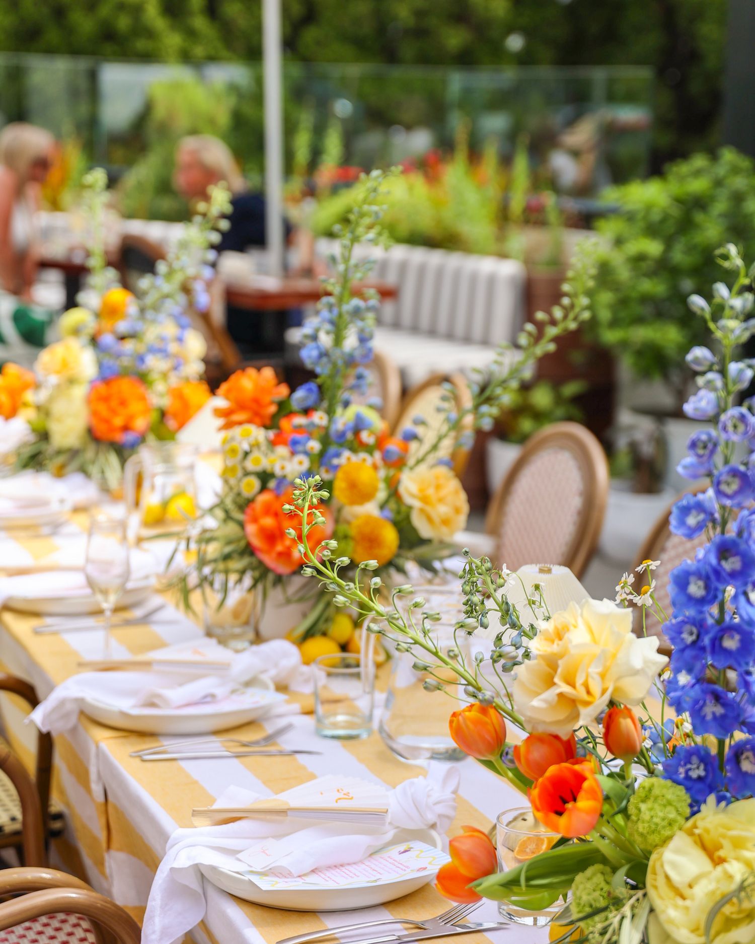A floral display on a table for a birthday summer garden party in the courtyard at Brigitte’s Merivale