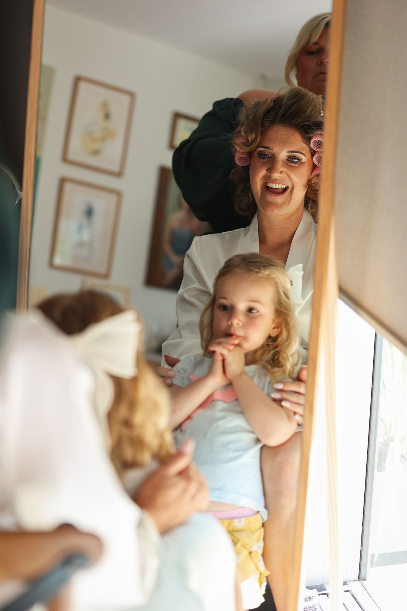 Bride and her daughter looking into the mirror as mum gets her makeup done.