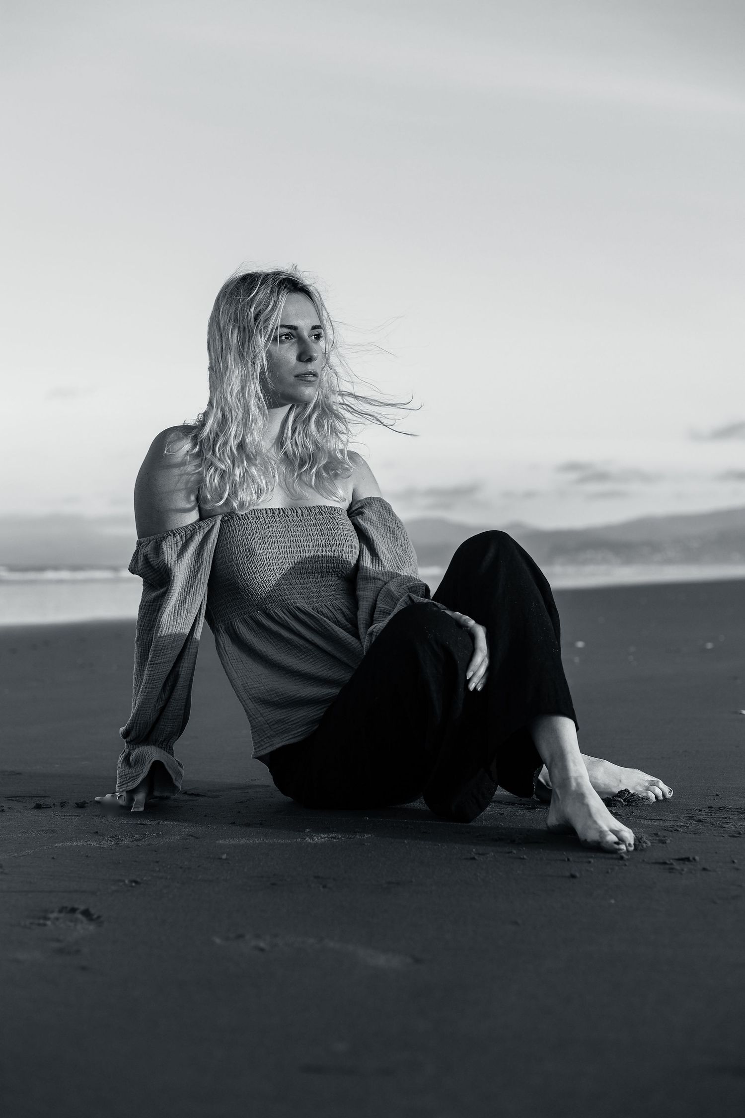 Model sitting on the beach for headshot portfolio photos.