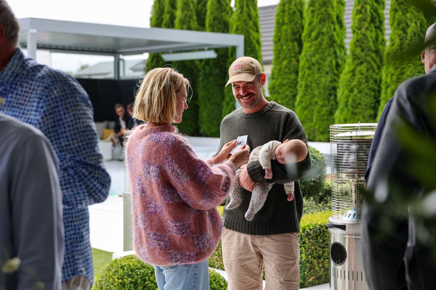 Candid moment of a couple standing and chatting with friends during an event