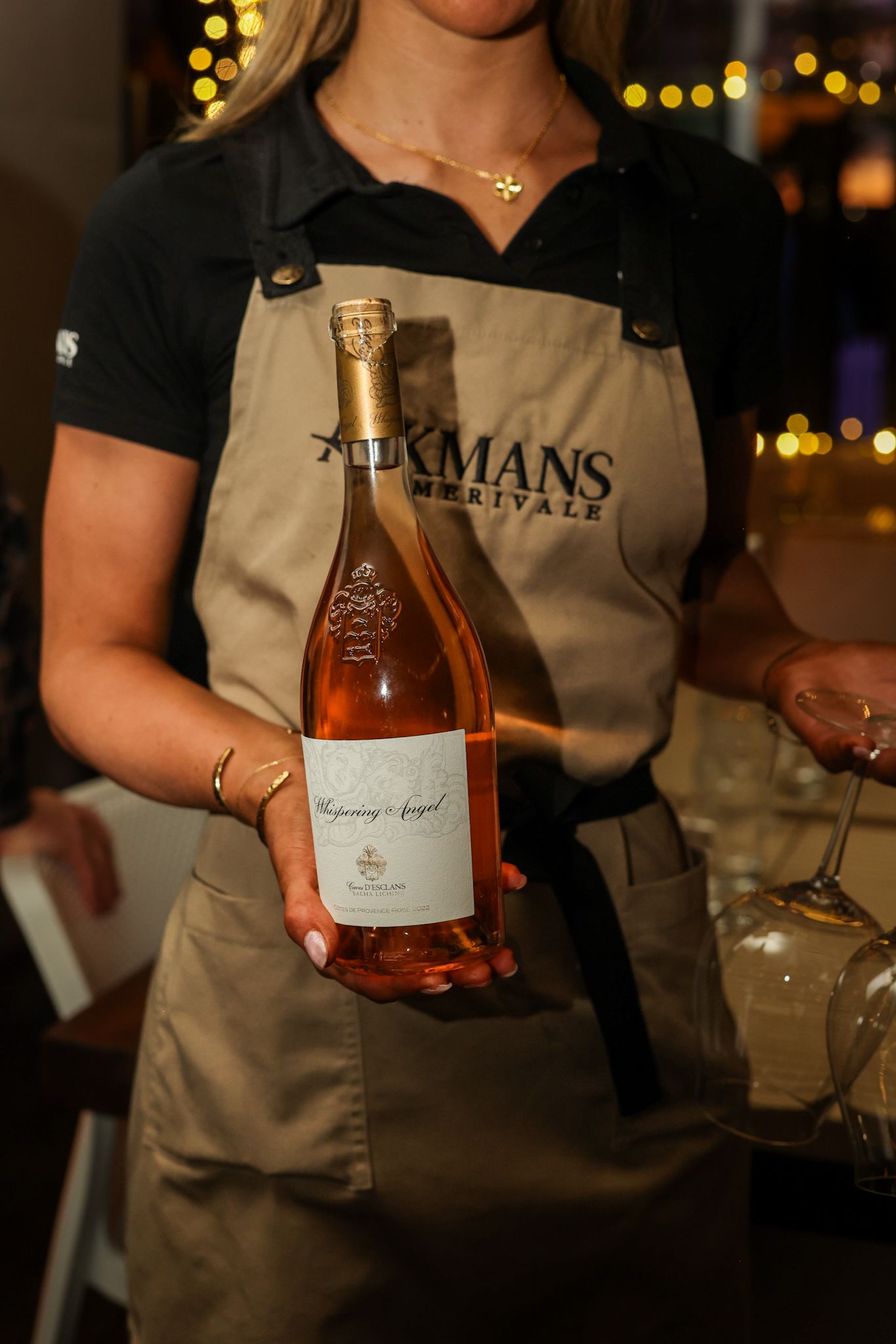 Waitress serving a bottle of Whispering Angel Rosé