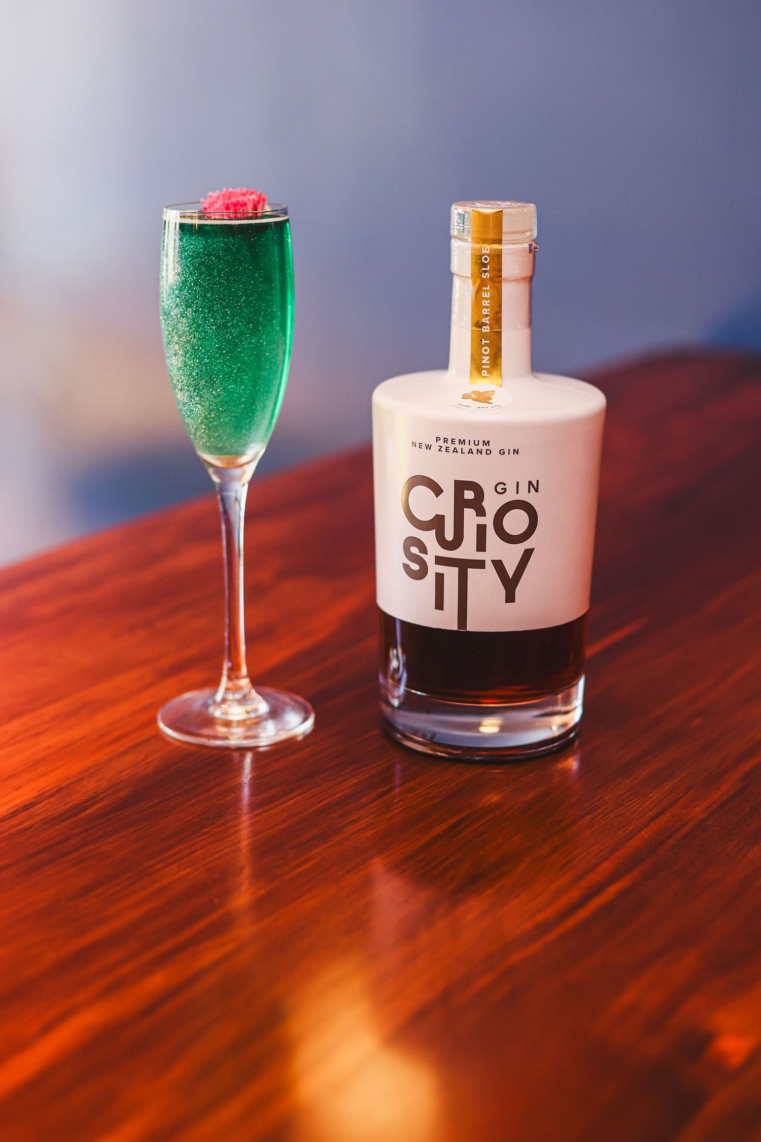 Curiotity sloe gin with a blue sparkly cocktail.