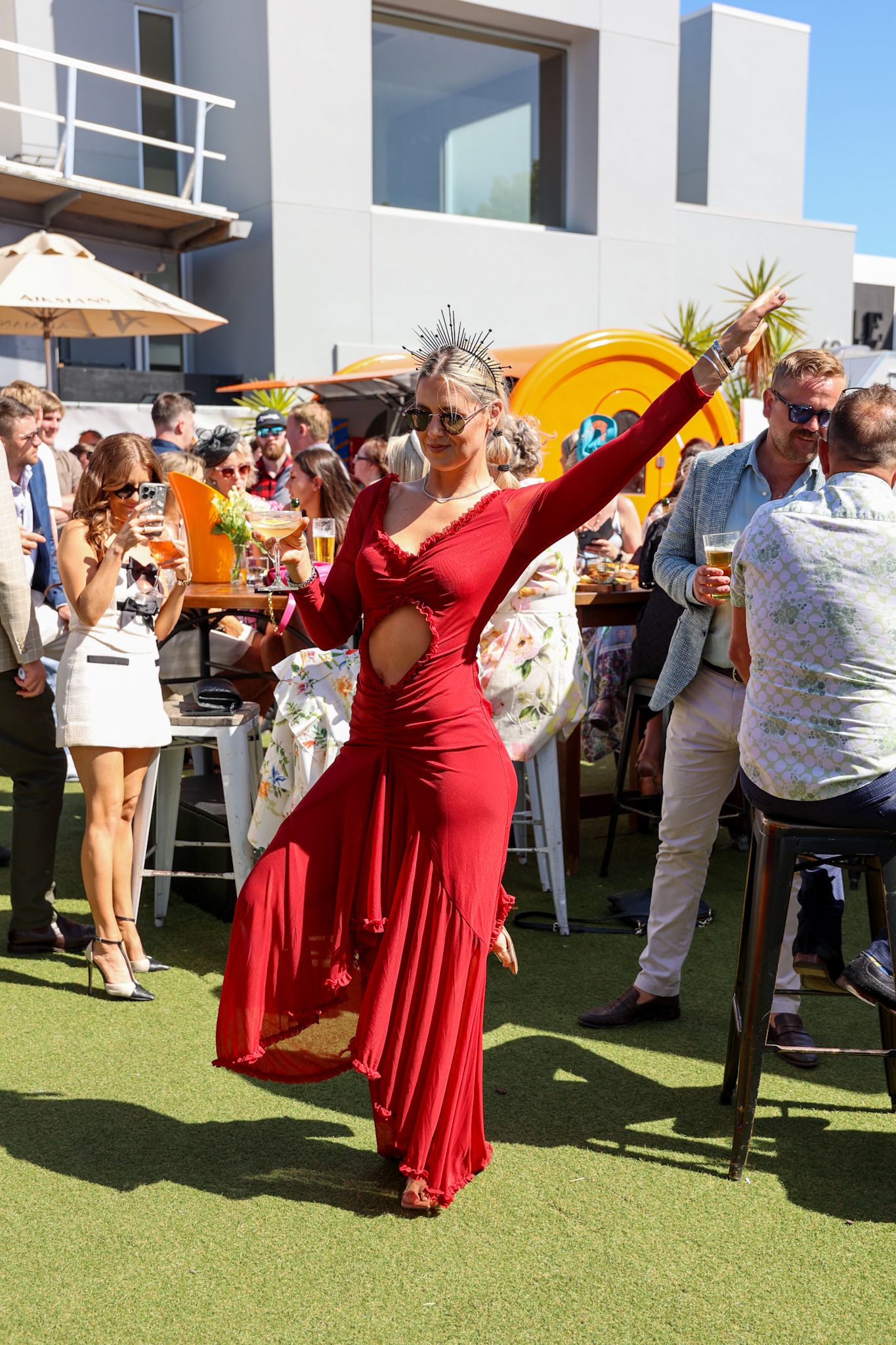 Lady dancing in a bar wearing a red dress.