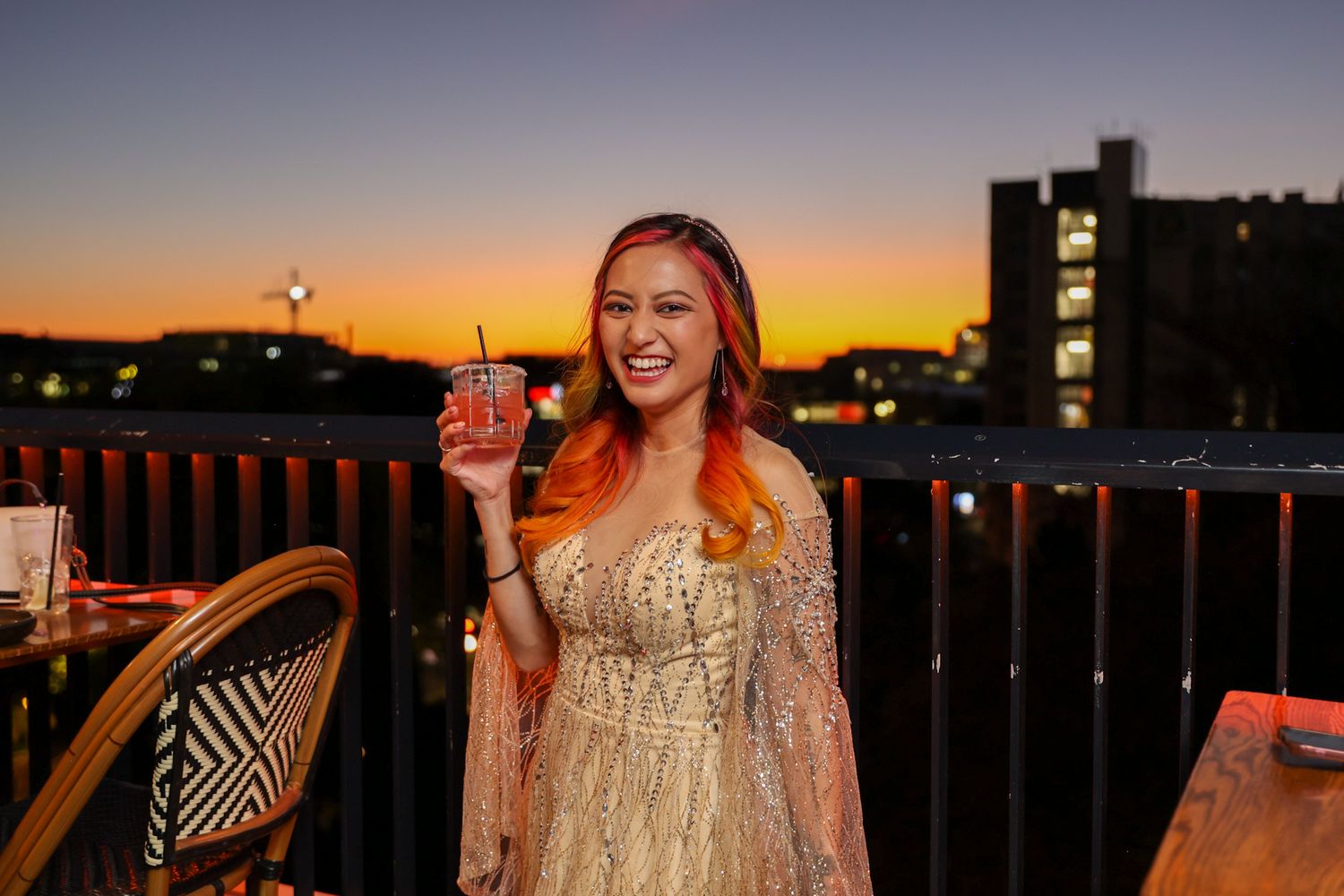 Birthday girl having her portrait taken at Mr. Brightside Rooftop Bar with the sun setting in the background.