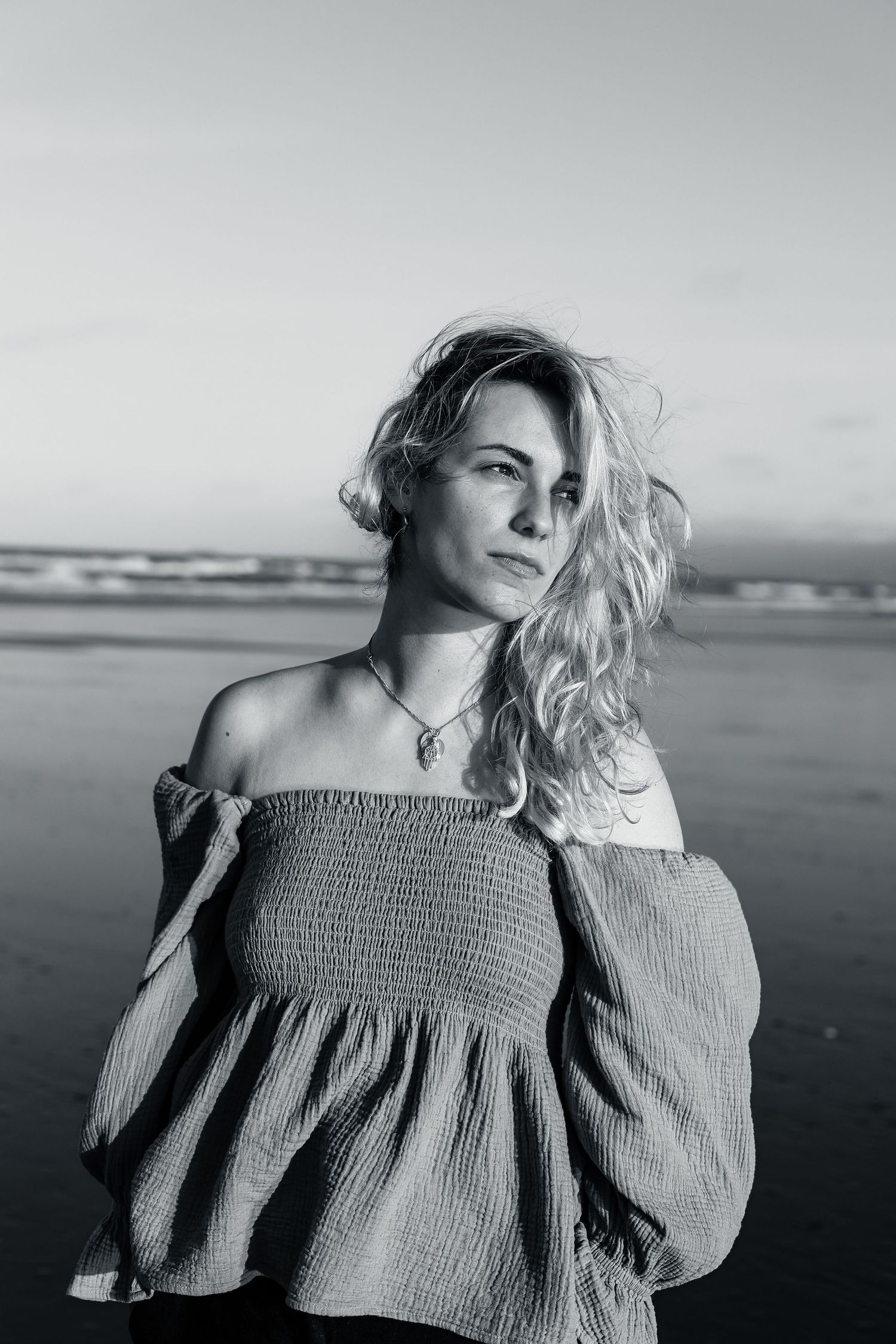 Model sitting on the beach for headshot portfolio photos.