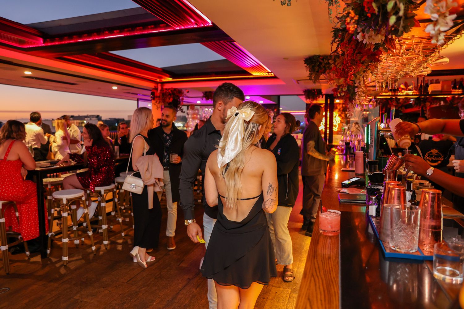 Party guests at a function getting drinks at the bar.