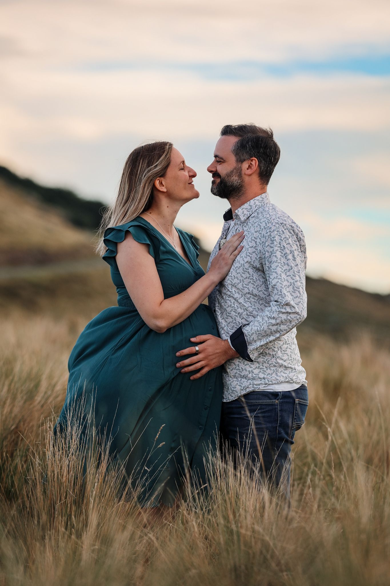 Expecting couple standing together in the Christchurch Port Hills during their maternity photoshoot.