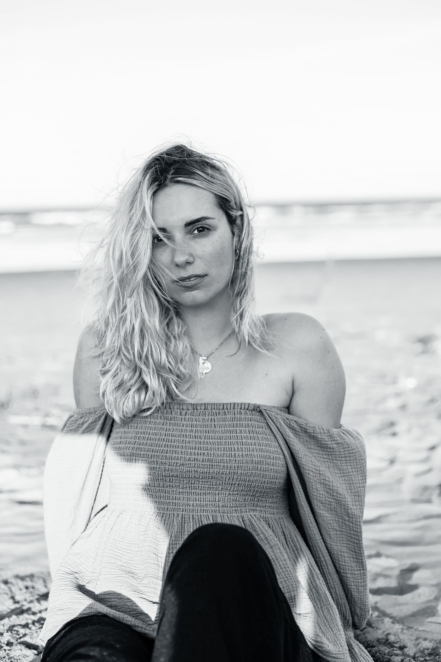 Model sitting on the beach for headshot portfolio photos.