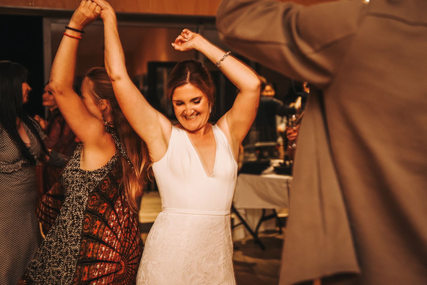 Bride and friend spinning and dancing on the dance floor at her wedding