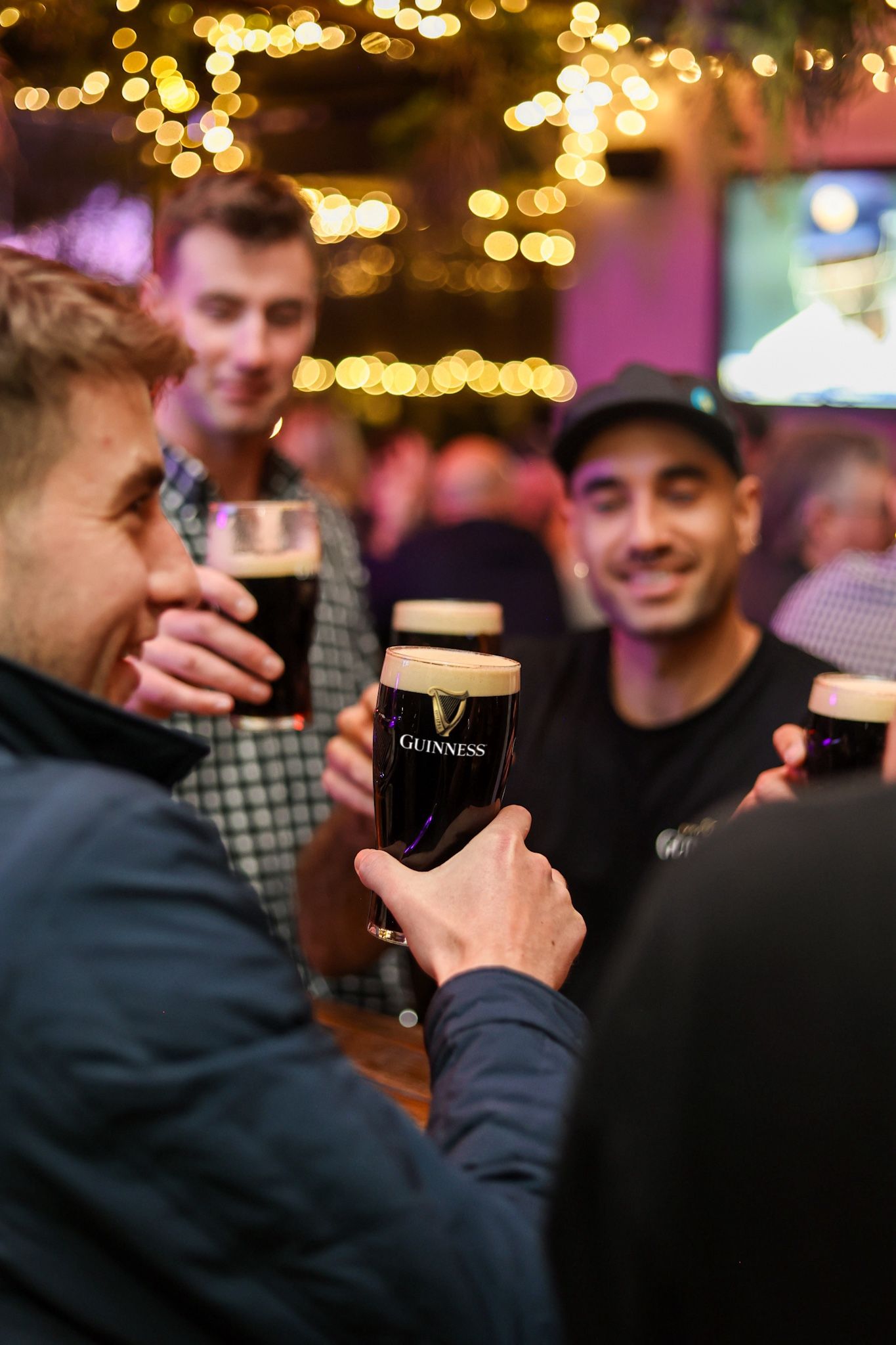 Boys cheersing a round of Guinness pints