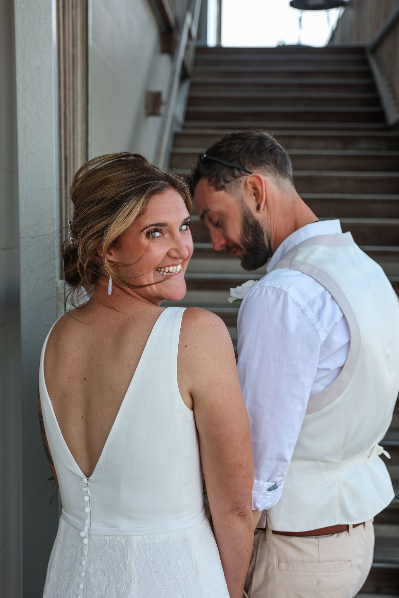 Bride looks over her shoulder before running into the reception party