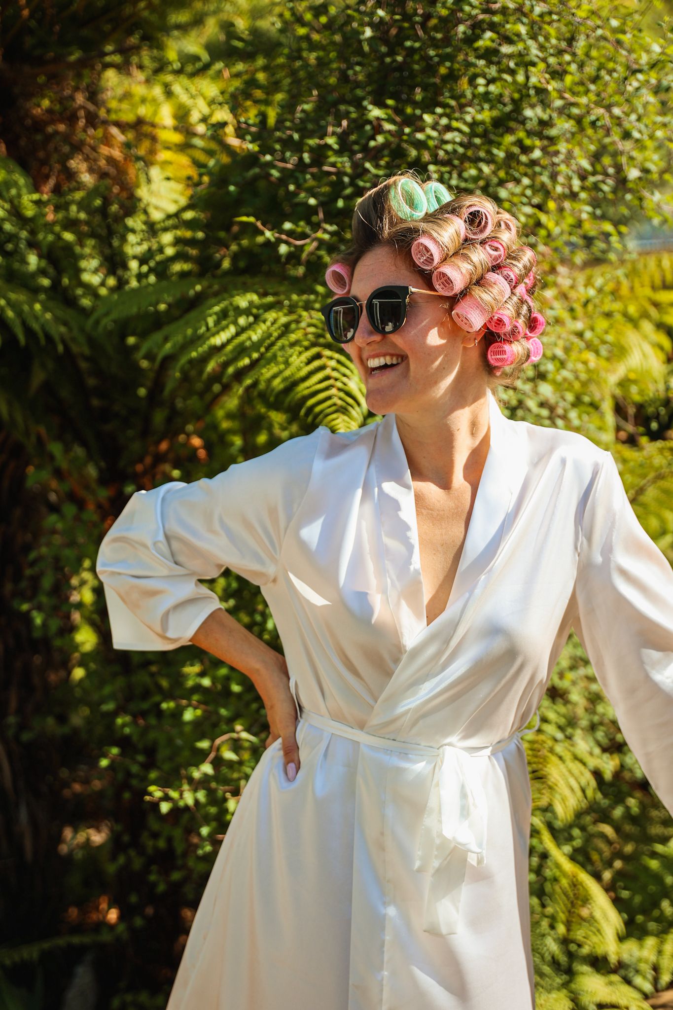 Bride posing with rollers and sunglasses before getting ready for the day