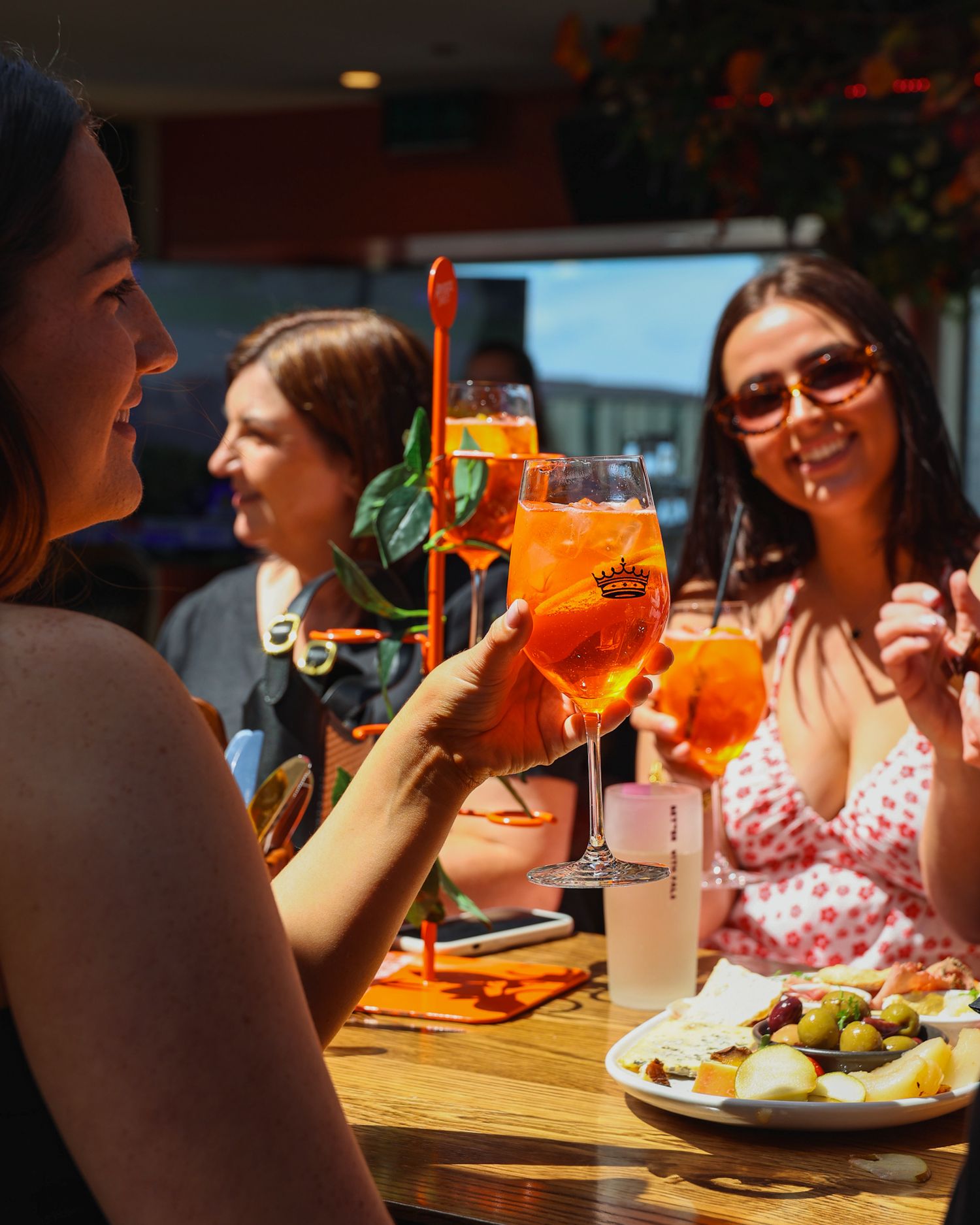 A group enjoying a round of Aperol Spritz in the sun at Mr. Brightside Rooftop Bar