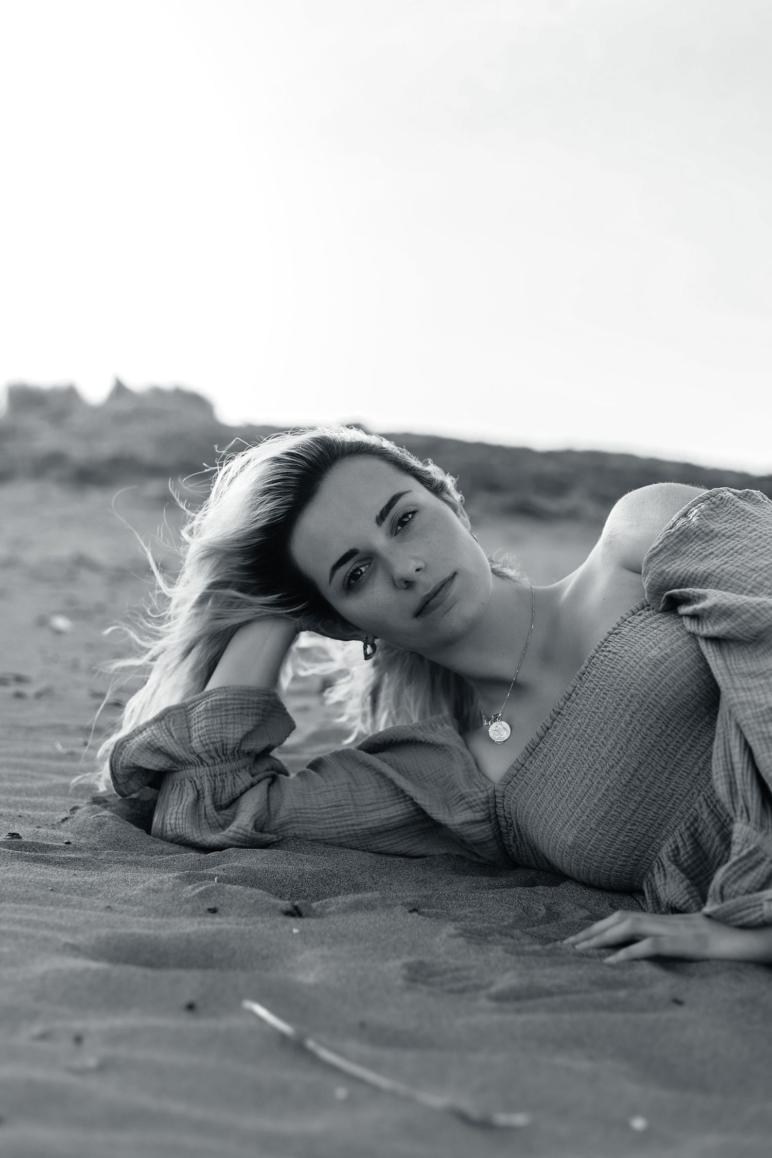 Model sitting on the beach for headshot portfolio photos.