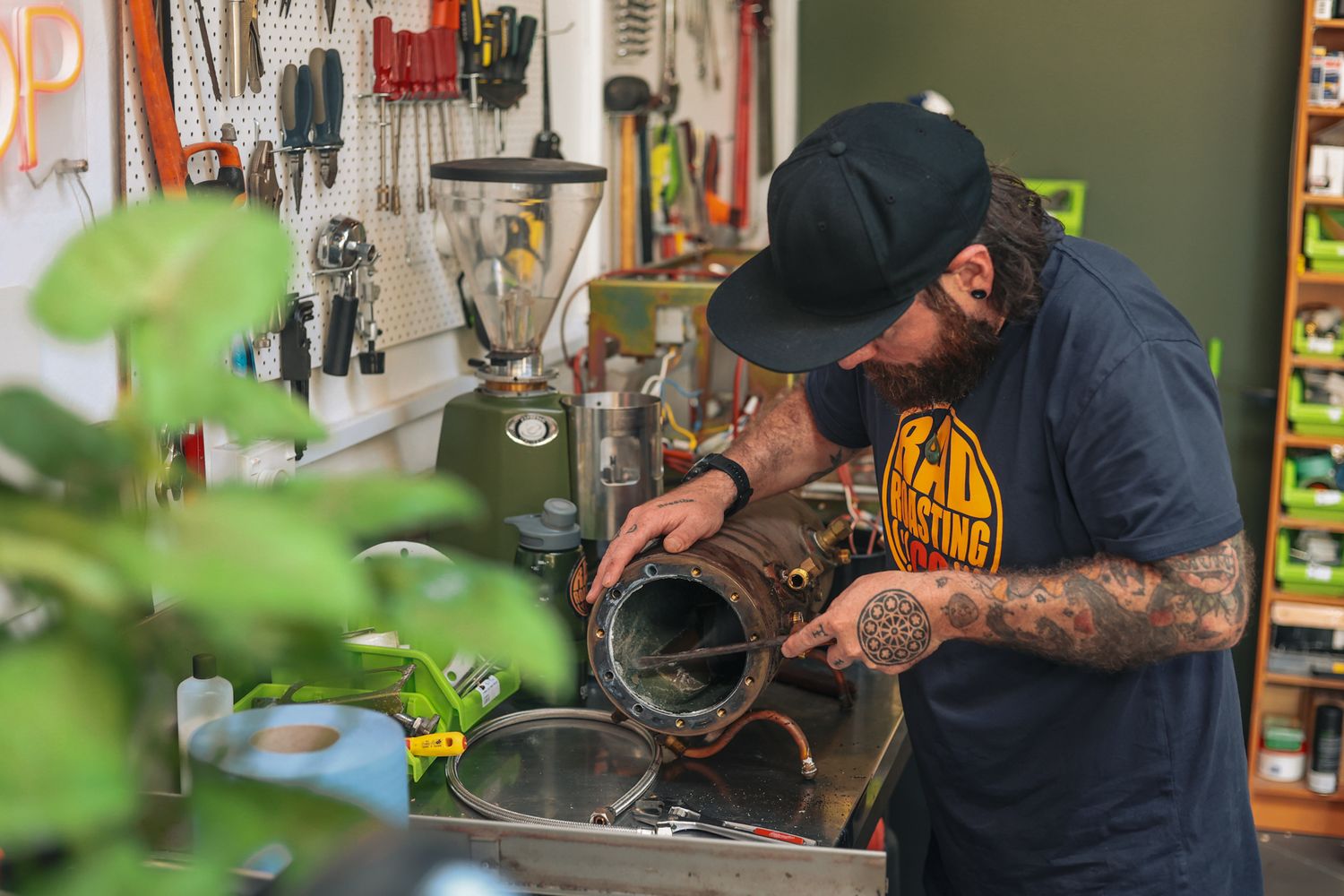 Rad Roasting Co. Owner fixing an old vintage coffee machine.