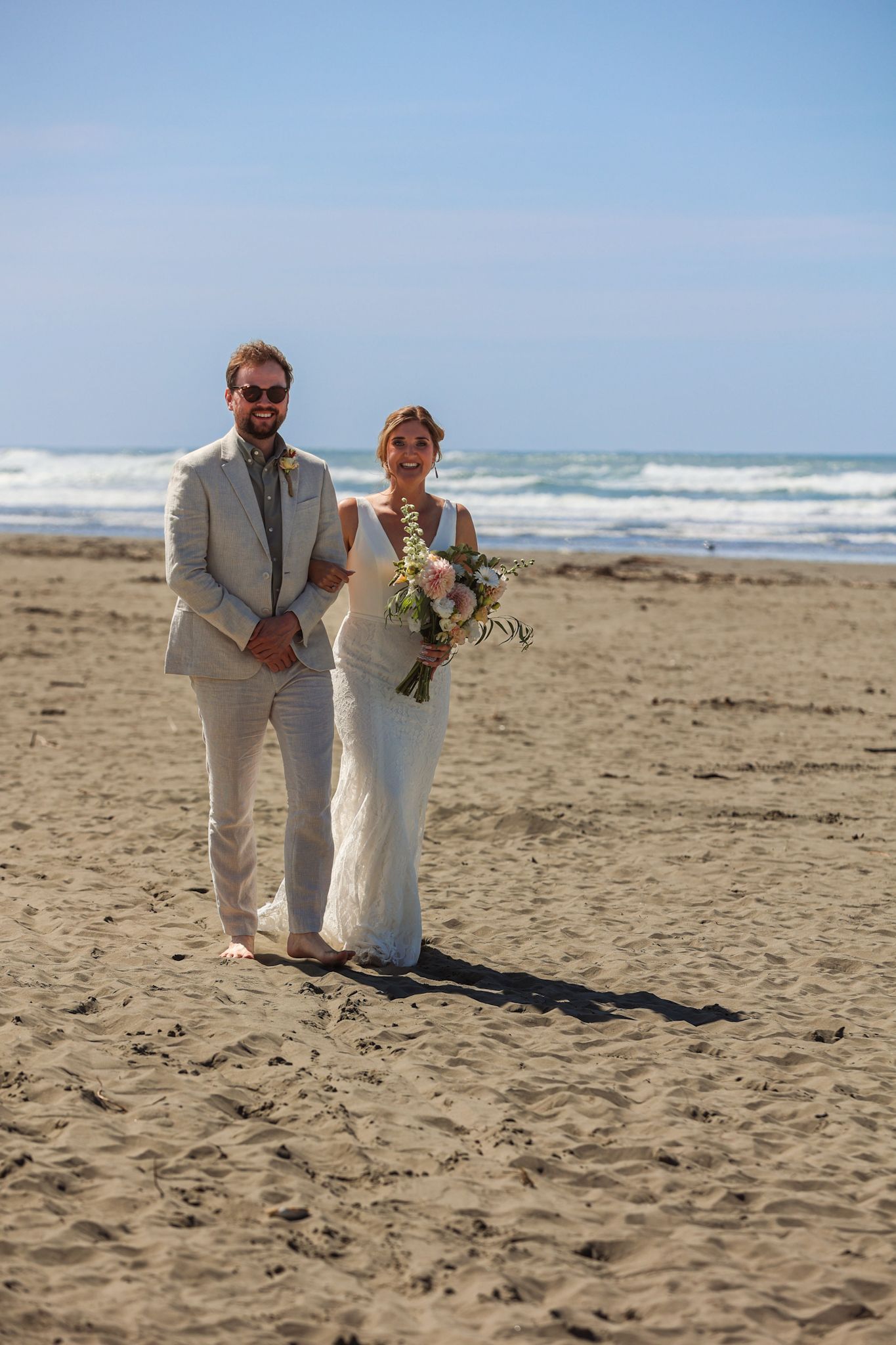 Bride walks down the beach aisle