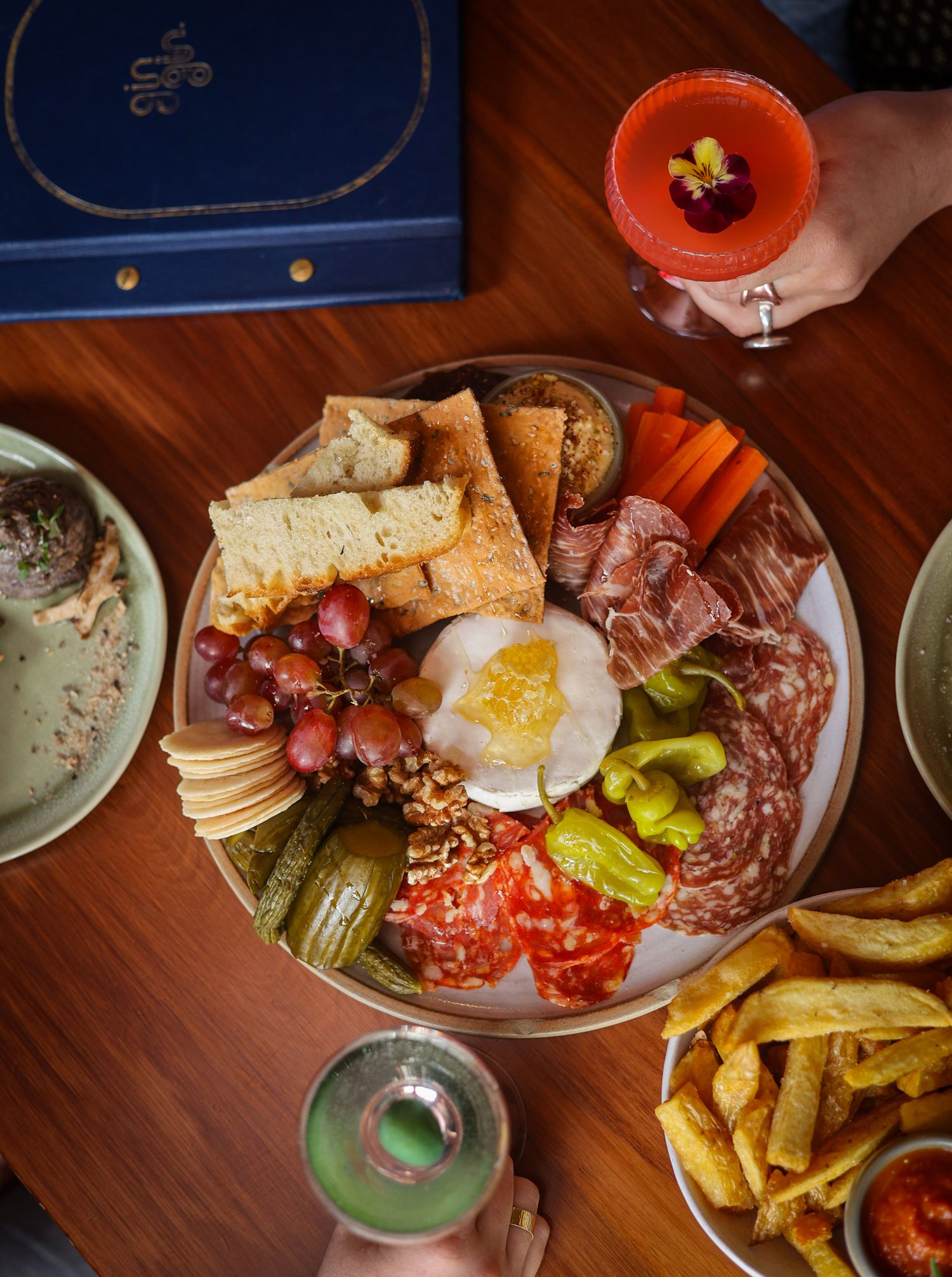 Overhead view of a cheeseboard and two cocktails at Gin Gin bar Christchurch.