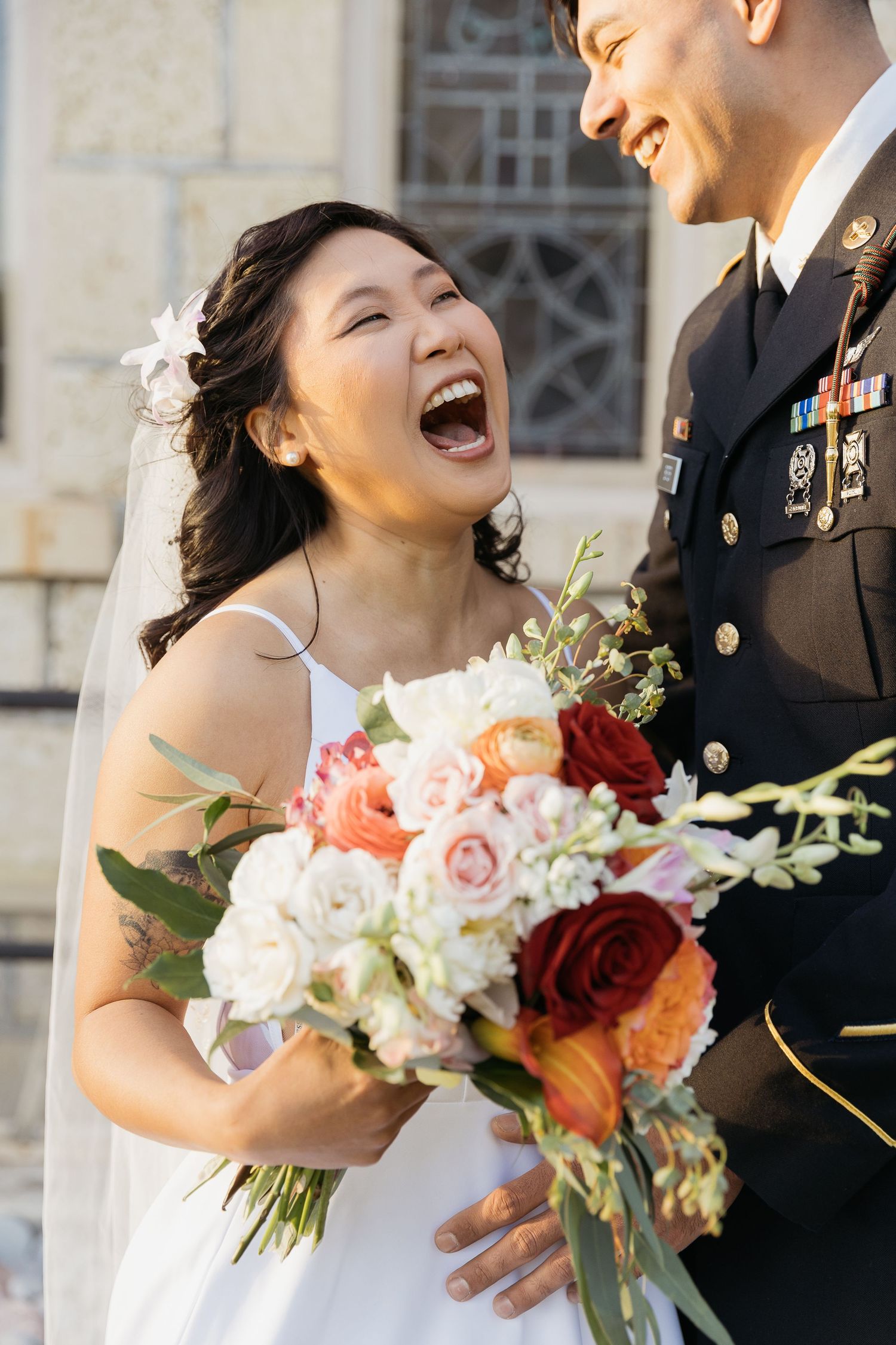 Joyful moment captured during outdoor wedding with bright florals and formal attire.