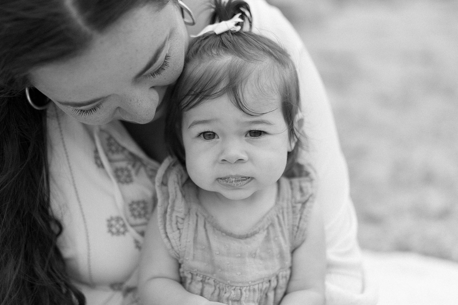Black and white intimate portrait of parent and child sharing a close moment.