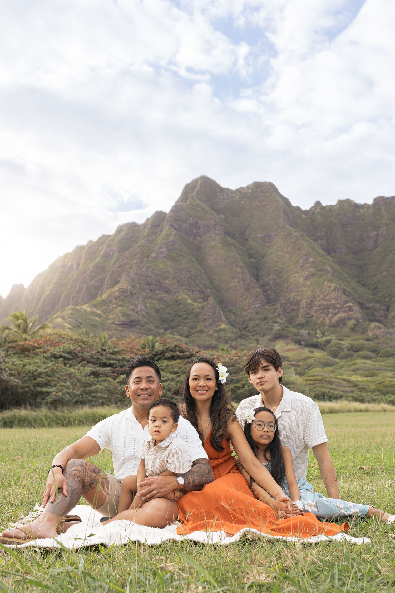 Beautiful family portrait in front of dramatic mountain landscape at sunset.
