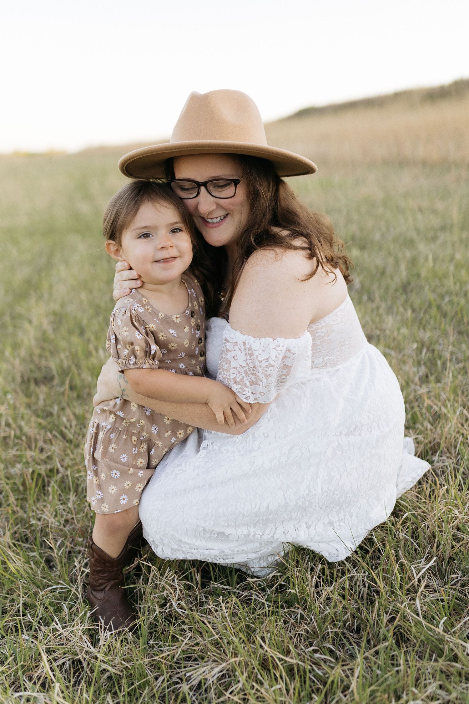 A heartwarming outdoor family portrait on grass featuring matching brown accessories.