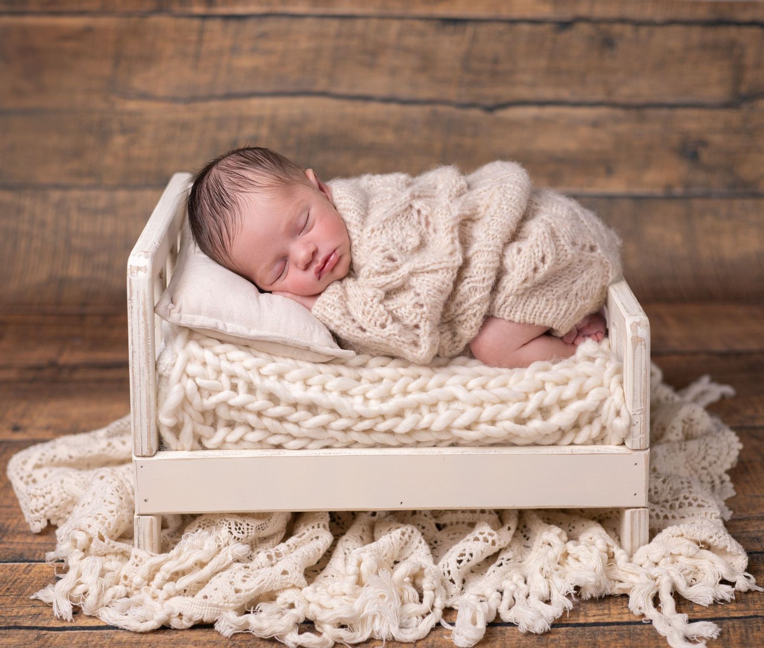 A newborn baby boy is posed in the bum-up position on a bed during his in-studio newborn photo shoot in Orange County, CA.