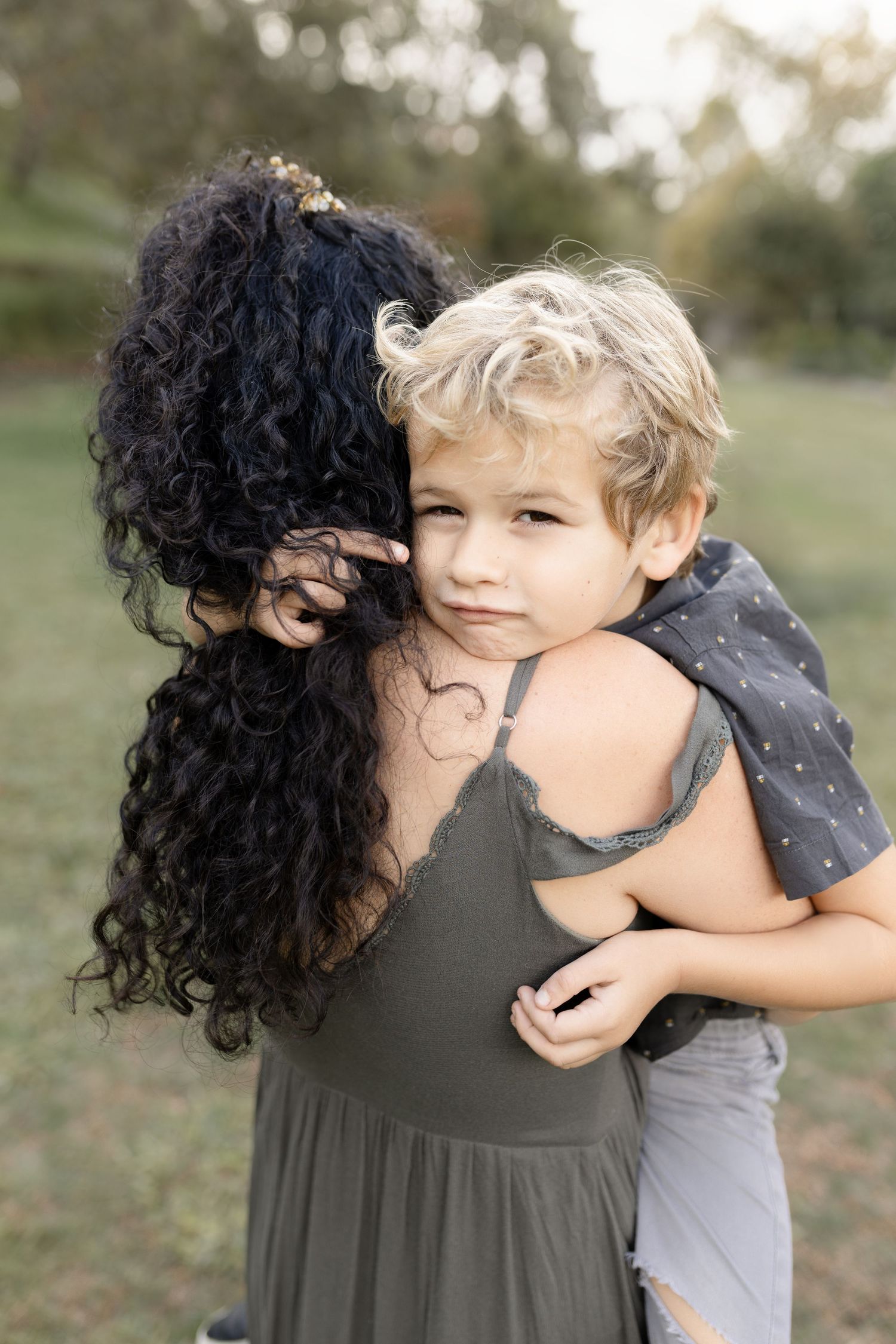 A boy shares a sweet moment with his mom during their family photography session, captured in a loving and tender pose.