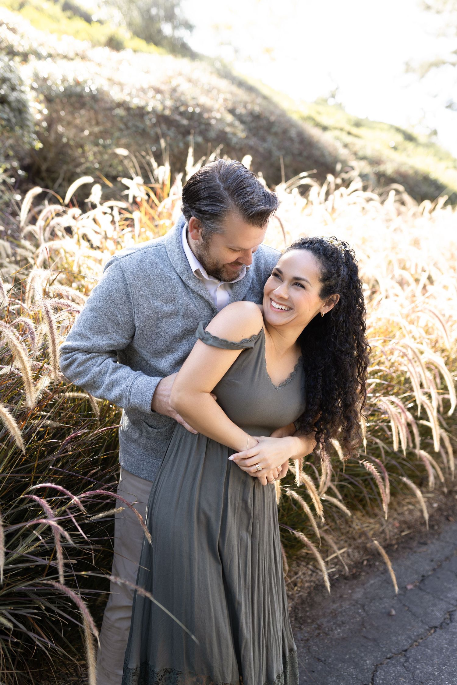 A couple poses together during their outdoor family photoshoot in Orange County, CA, surrounded by natural scenery.