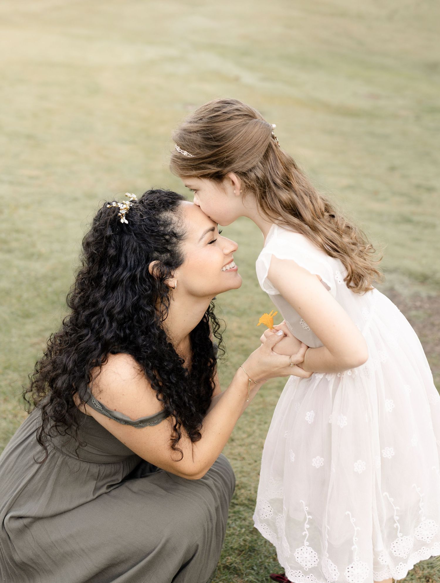 A daughter kisses her mom during their family outdoor session in Orange County, CA, capturing a tender and loving moment.