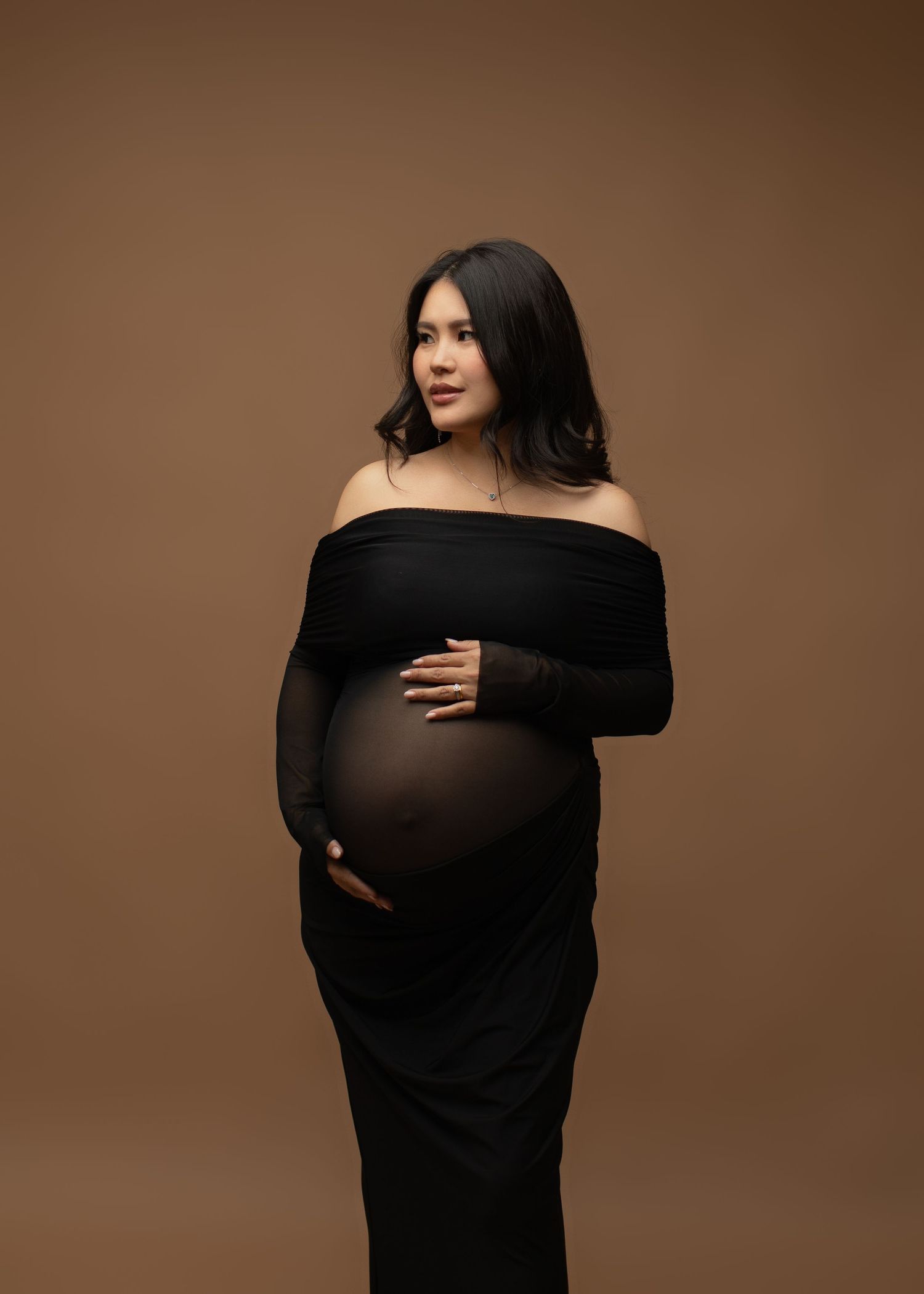 A minimal, timeless styled maternity photoshoot in the studio, featuring soft lighting and elegant simplicity.