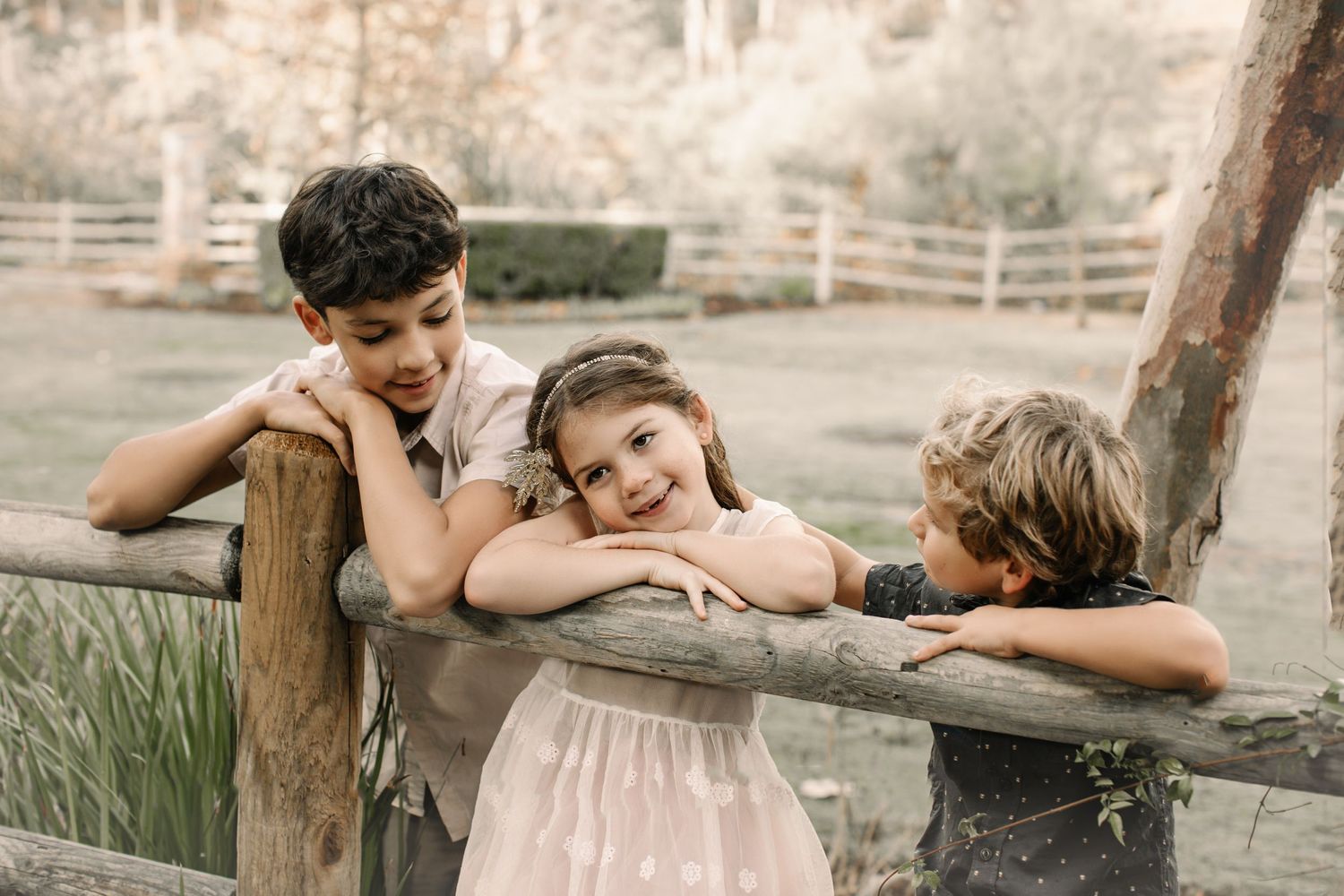 Siblings share a joyful moment together during an outdoor photo session, smiling and laughing.