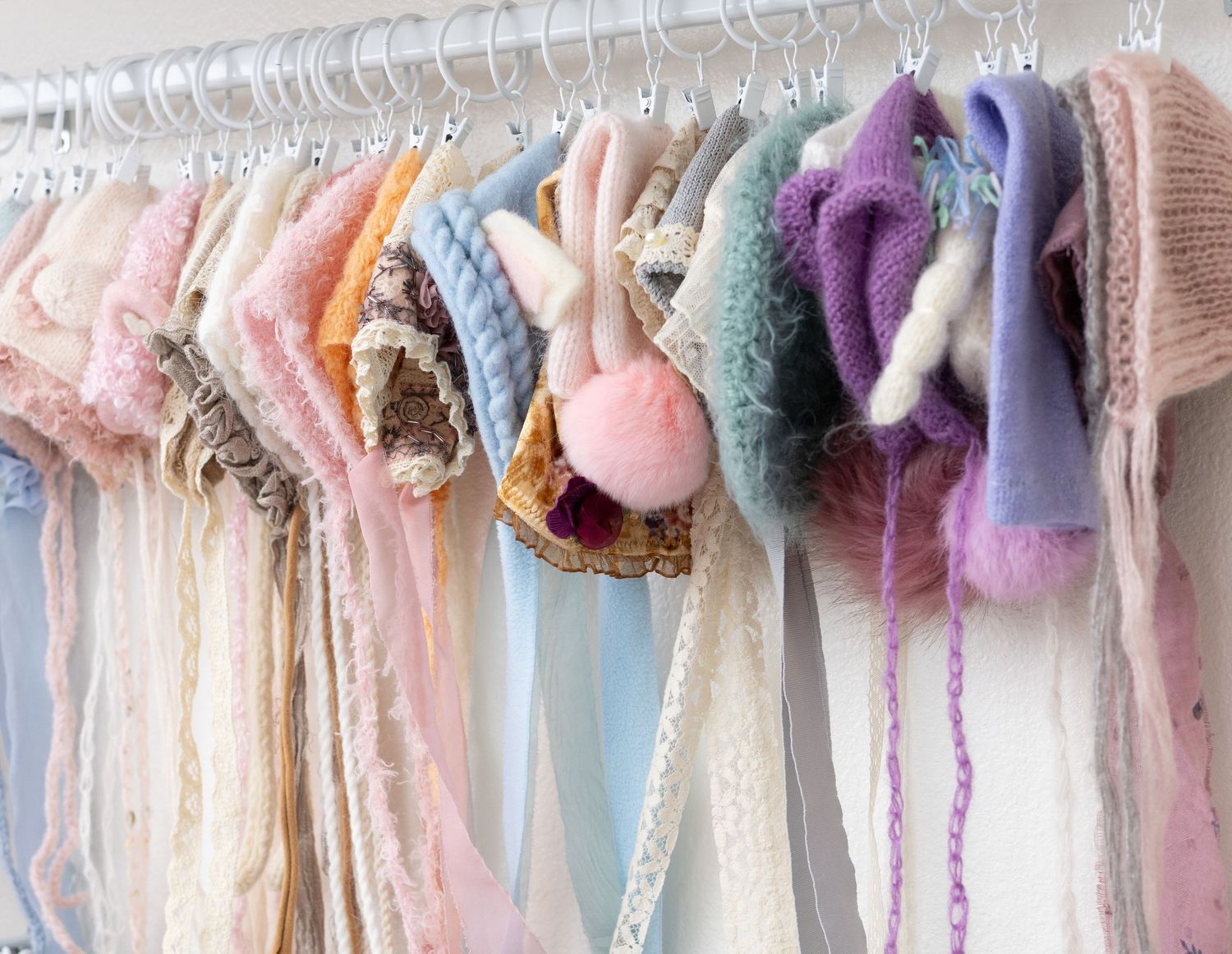 A selection of cute girl bonnets in various colors and styles, ready for newborn and baby photo sessions.