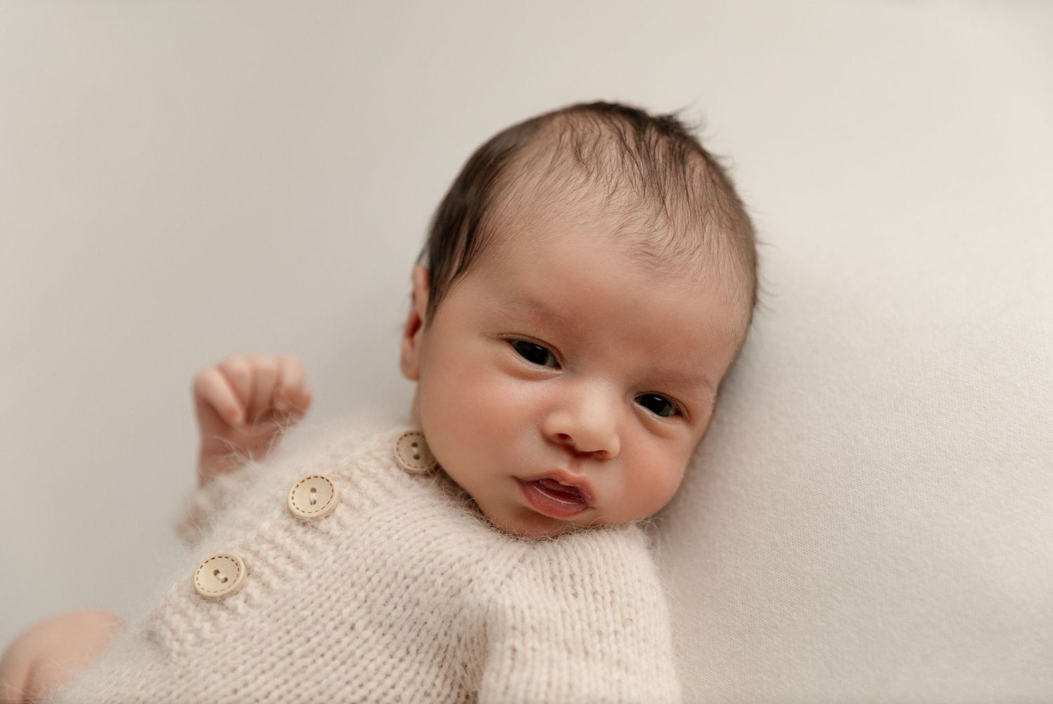 A newborn baby sleeps peacefully during an in-home session in Orange County, CA, with soft lighting and gentle props.