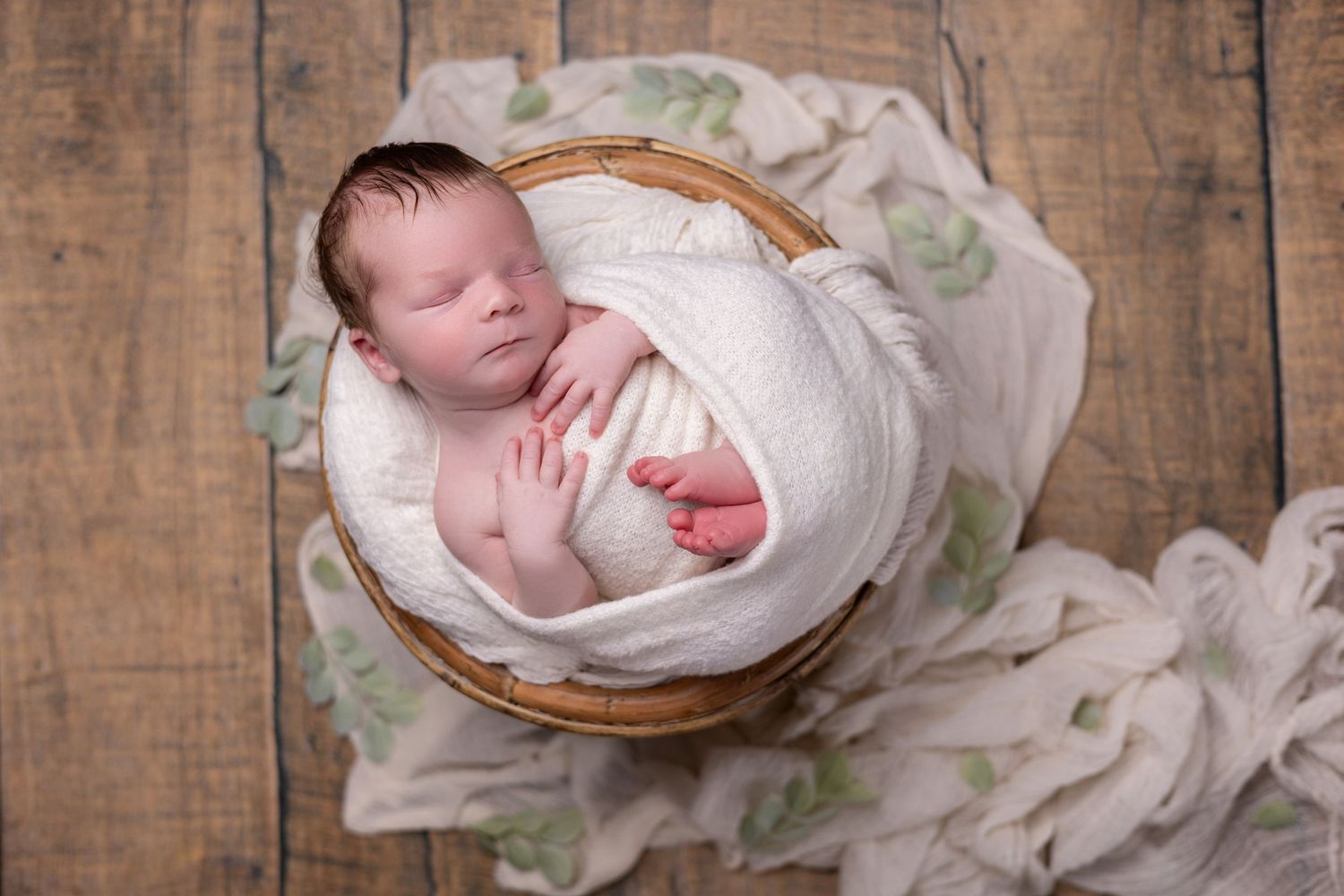 A newborn baby sleeps peacefully during a session in my Santa Ana studio, surrounded by soft props.
