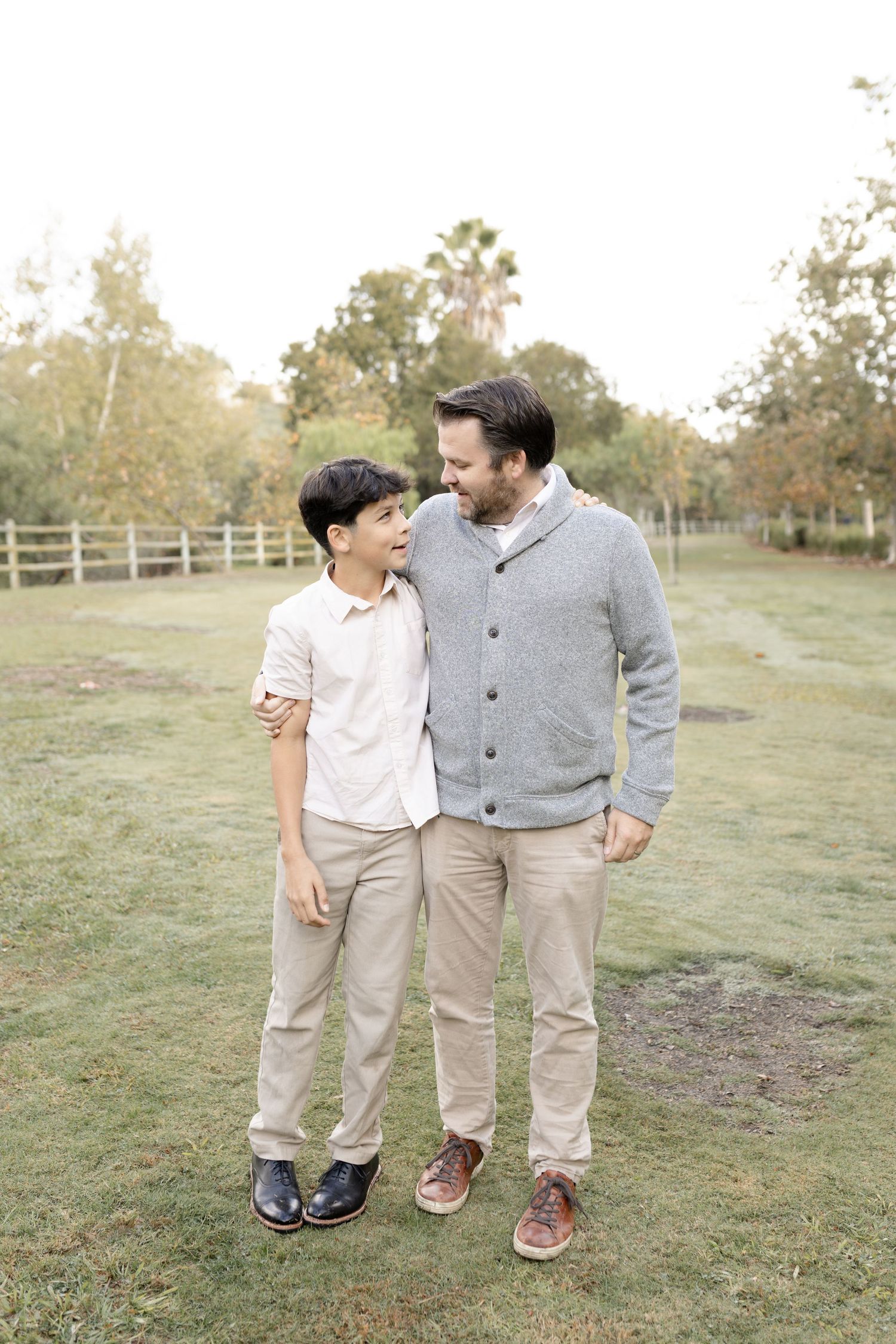 A dad and son pose together during their outdoor family session in Mission Viejo, capturing a playful and loving moment.