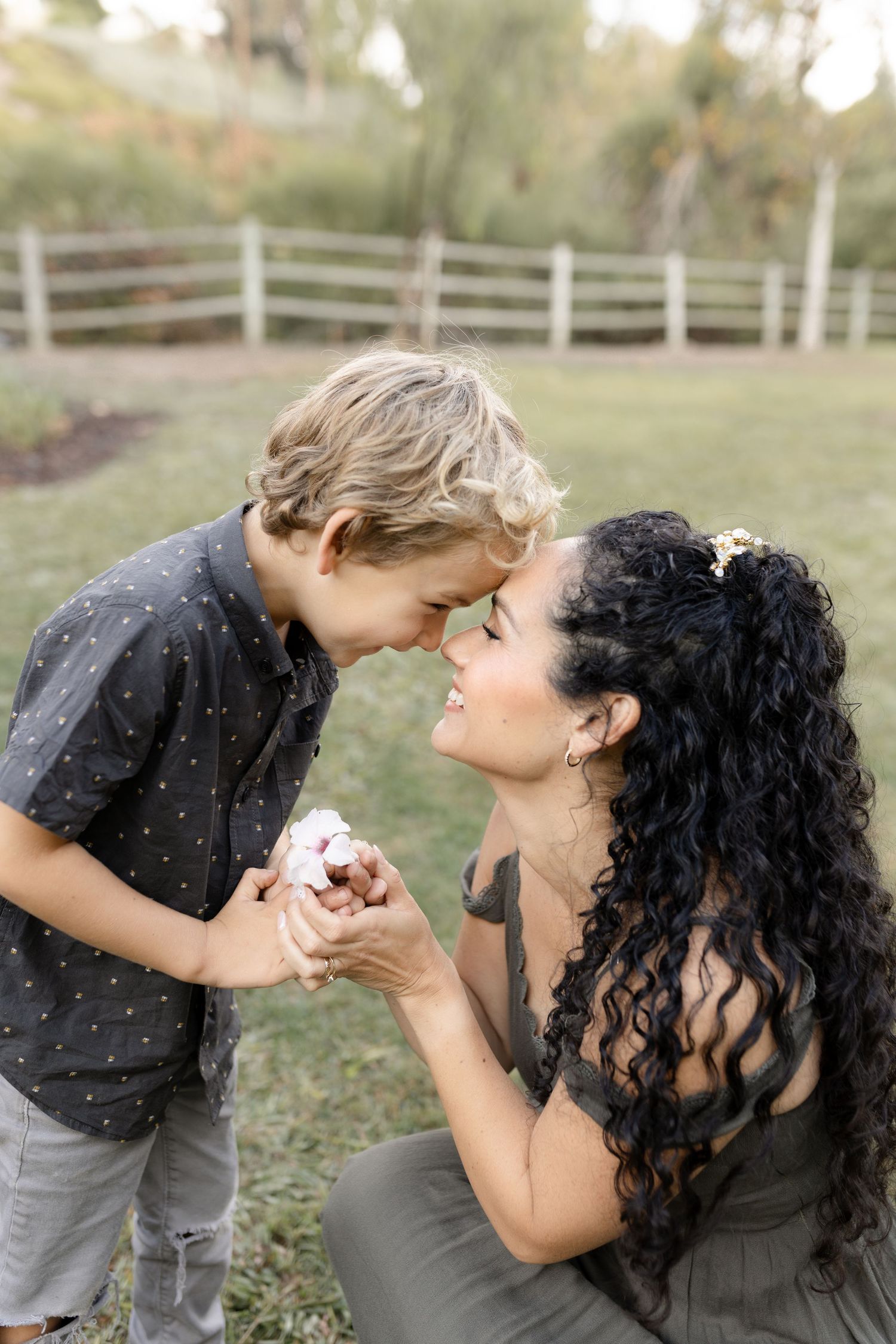 A mother and son pose together during their outdoor family session in Mission Viejo, capturing a sweet and loving moment.
