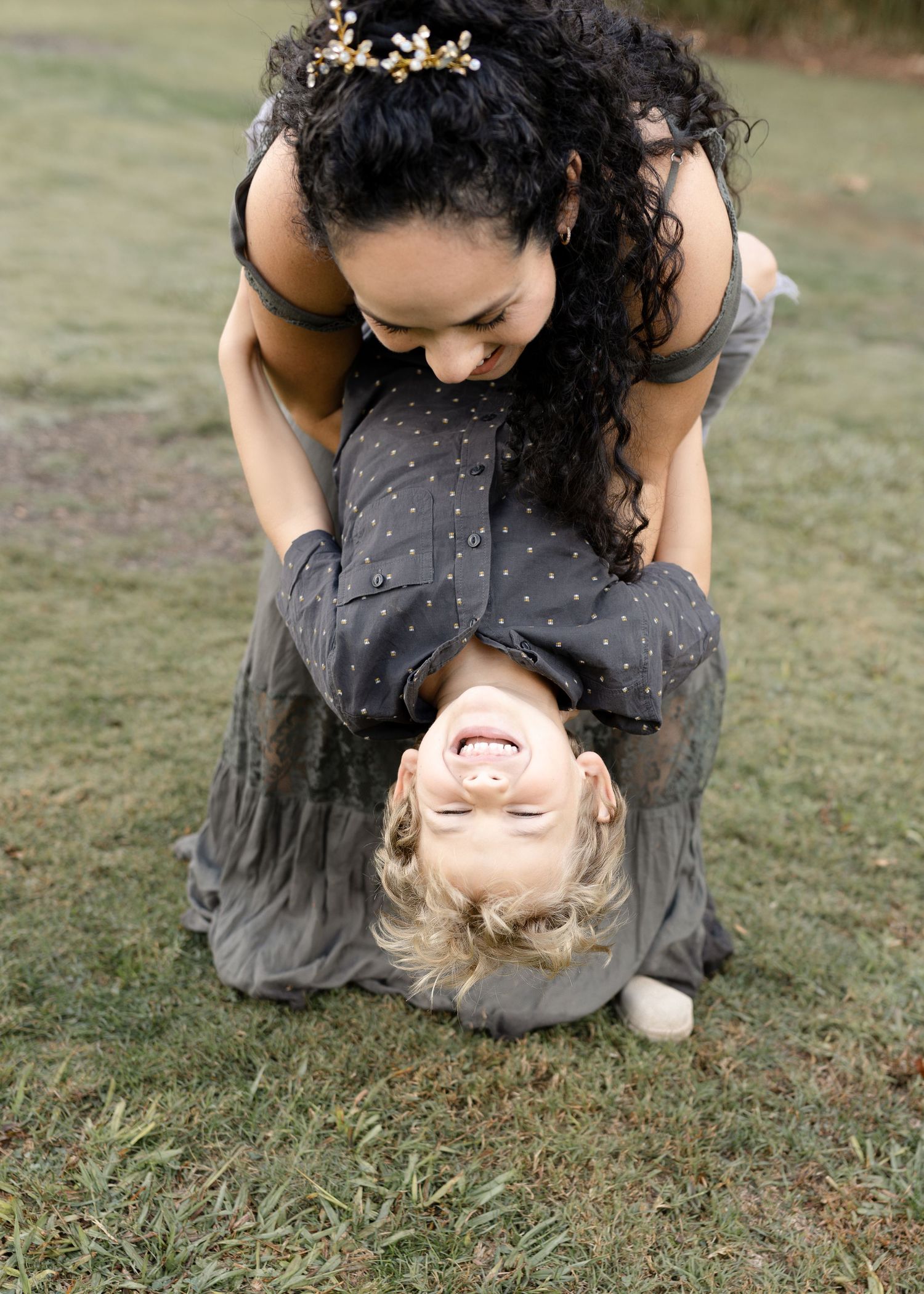 A young boy plays joyfully with his mom, sharing a fun and loving moment together.