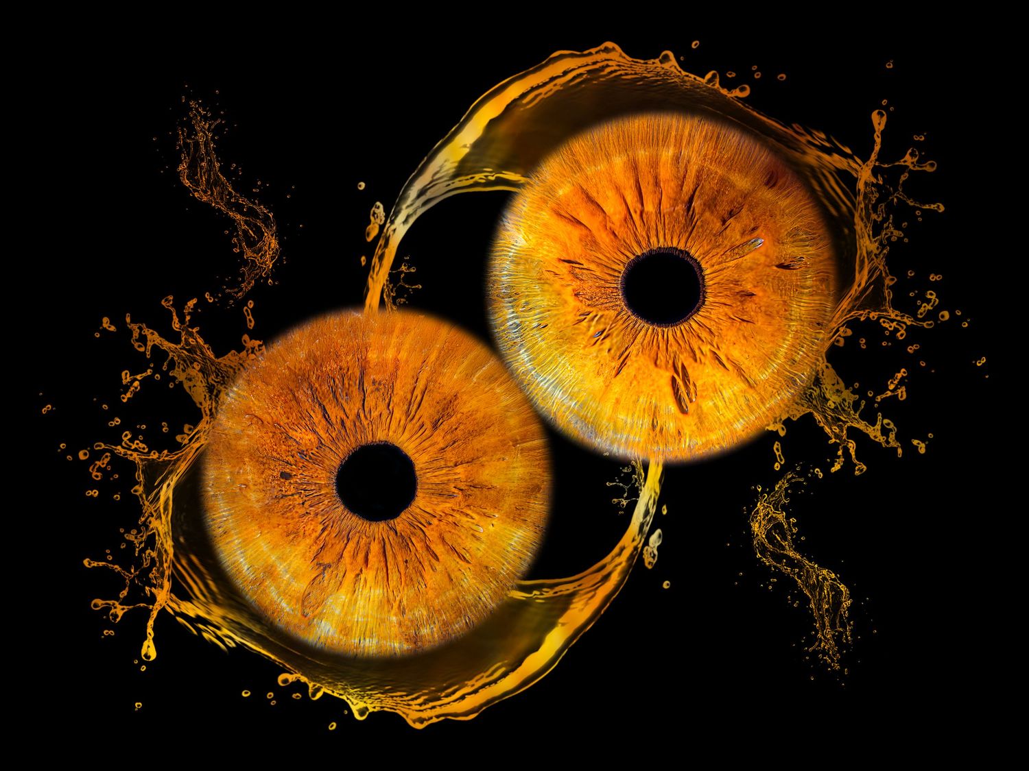 Two glowing golden-orange human eyes with detailed irises surrounded by liquid splashes on a black background.