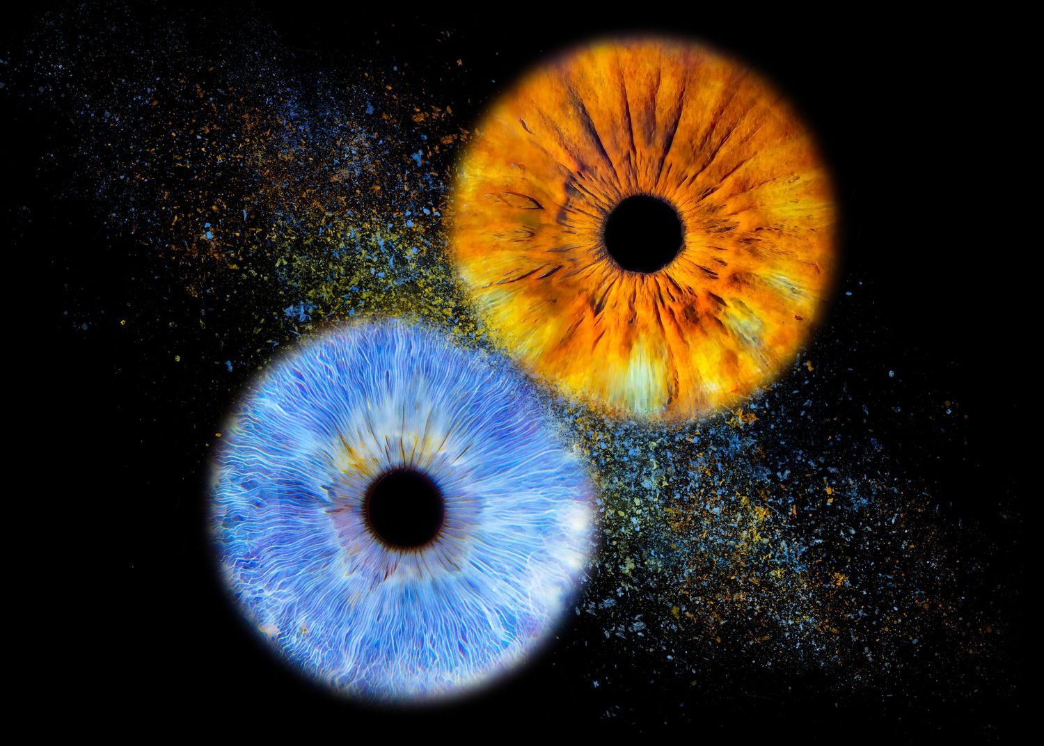 Two vivid human irises, one orange and one blue, glowing against a black background with colorful particle effects.