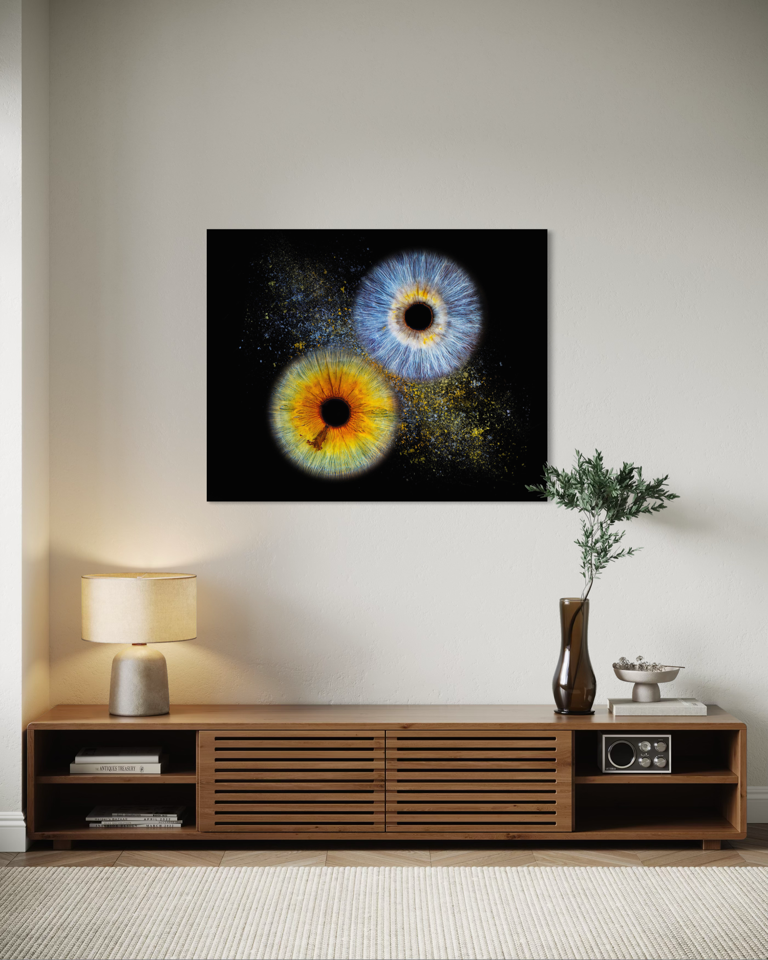 Macro iris art canvas featuring vibrant yellow-orange and blue eyes on black background, displayed above modern wood media console.