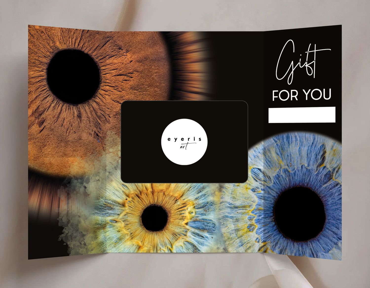 A gift card display featuring three artistic close-up photographs of human irises in brown, yellow and blue colors.