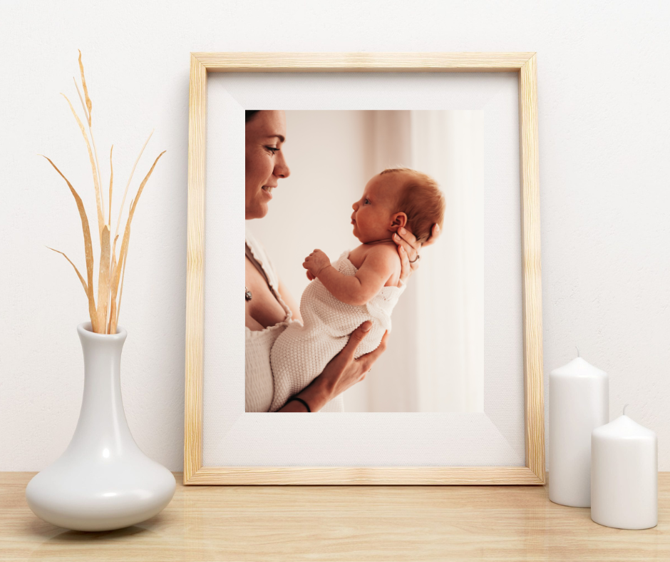 A framed photograph of a tender parent-child moment displayed with decorative vase and candles.