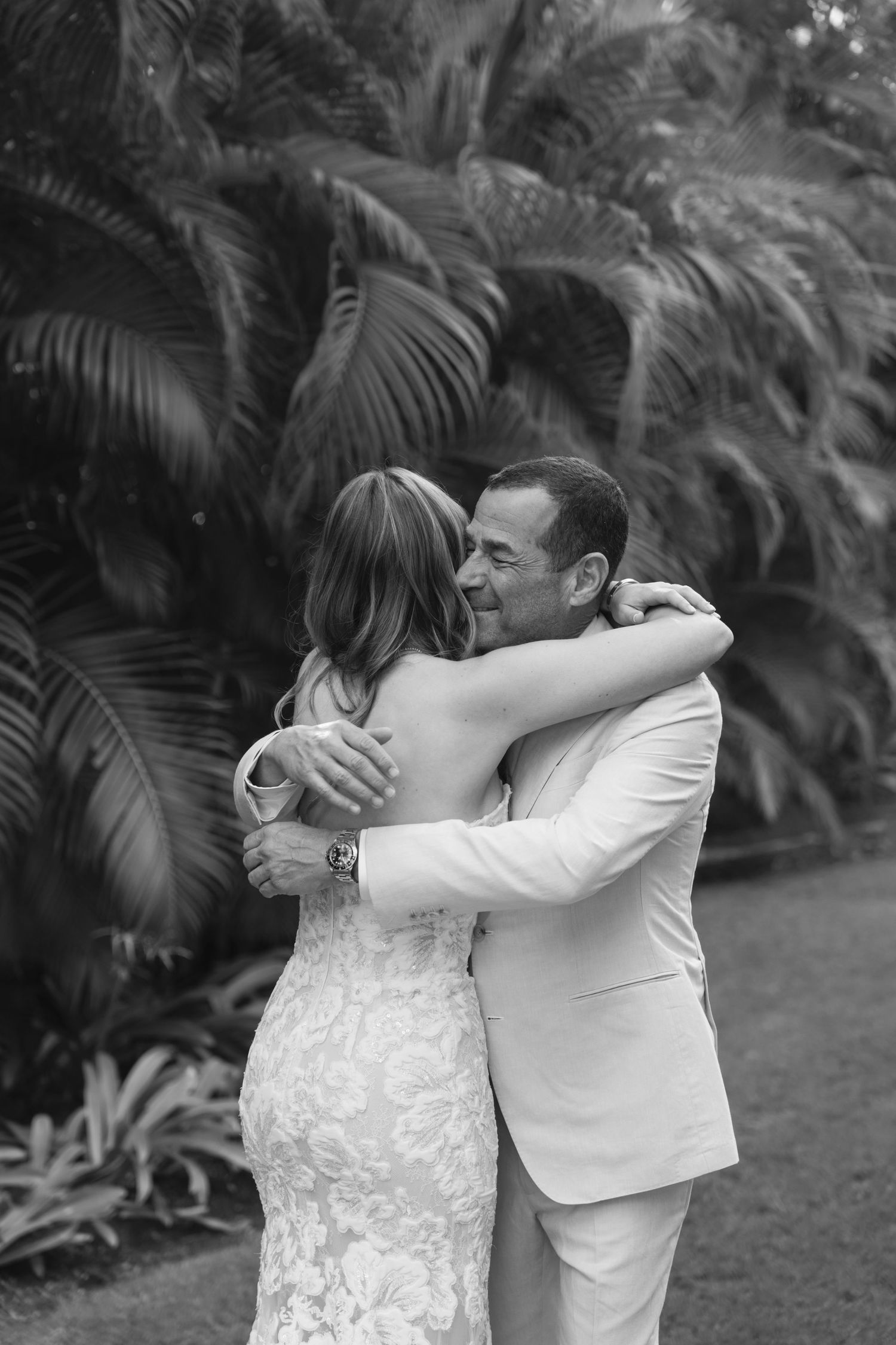A romantic black and white photo sequence shows a couple sharing a tender kiss in a tropical garden setting.