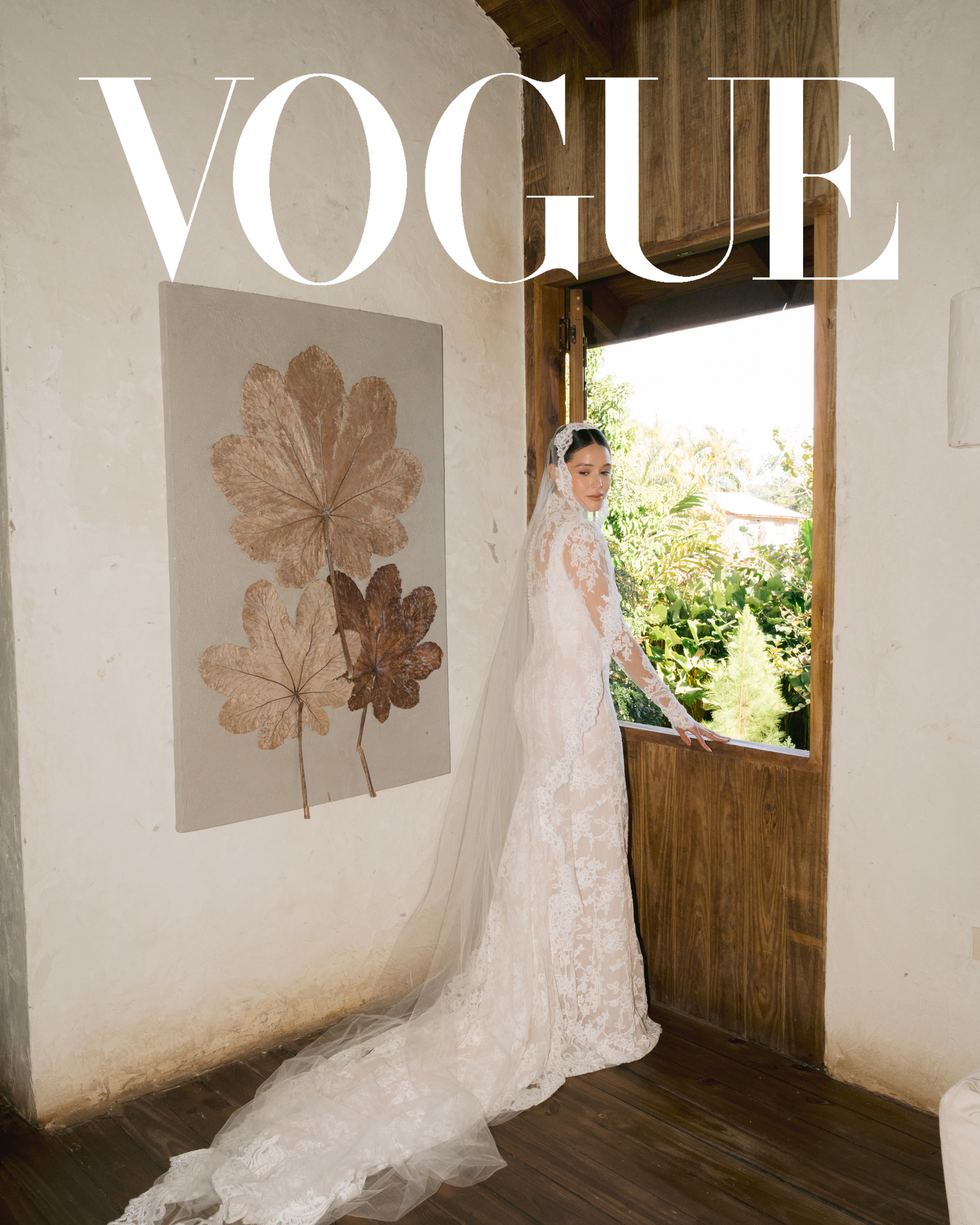 A bridal fashion photo in Vogue style showing a long lace wedding dress with dramatic train.
