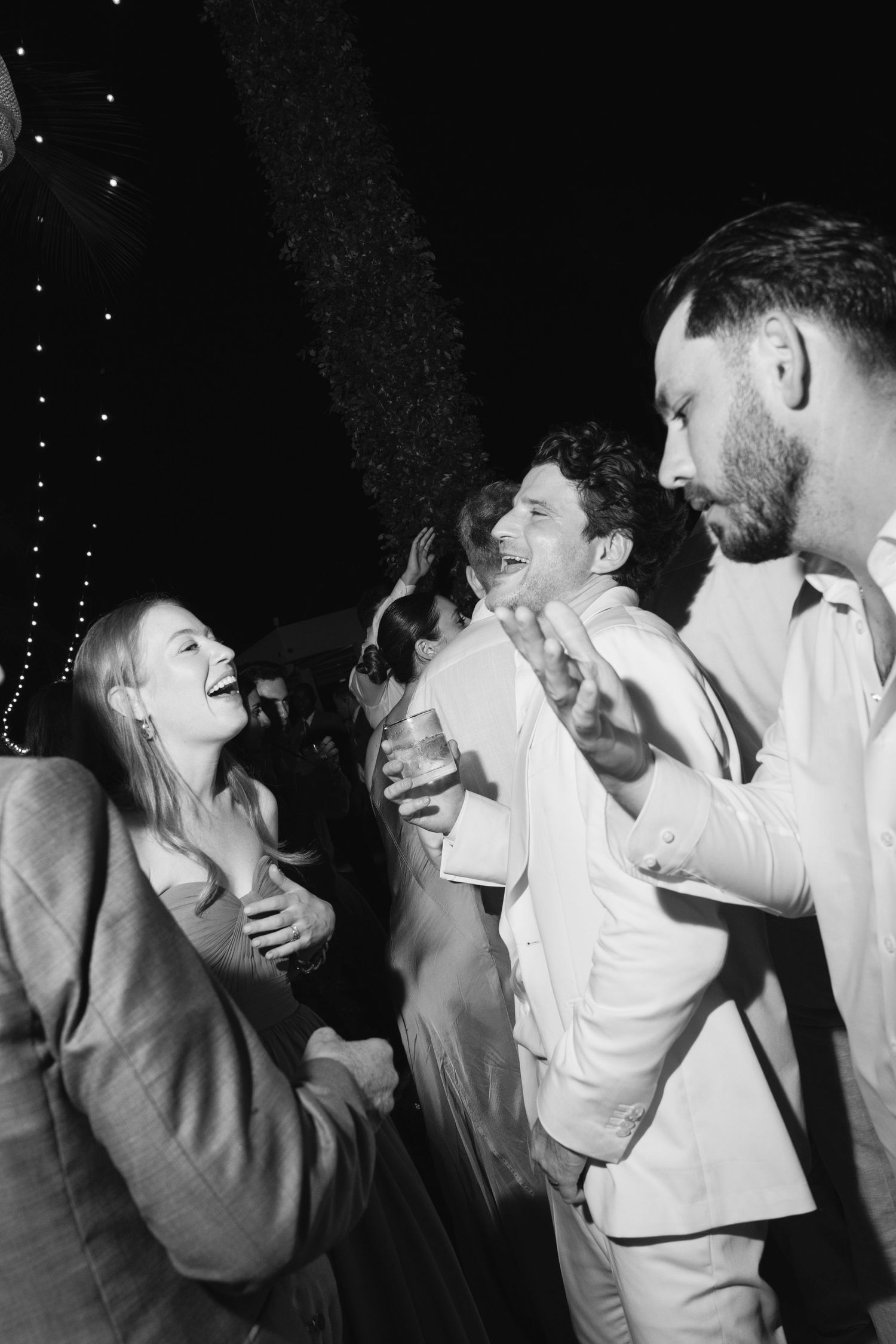 A romantic black and white photo sequence showing a couple dancing closely together in white formal attire.