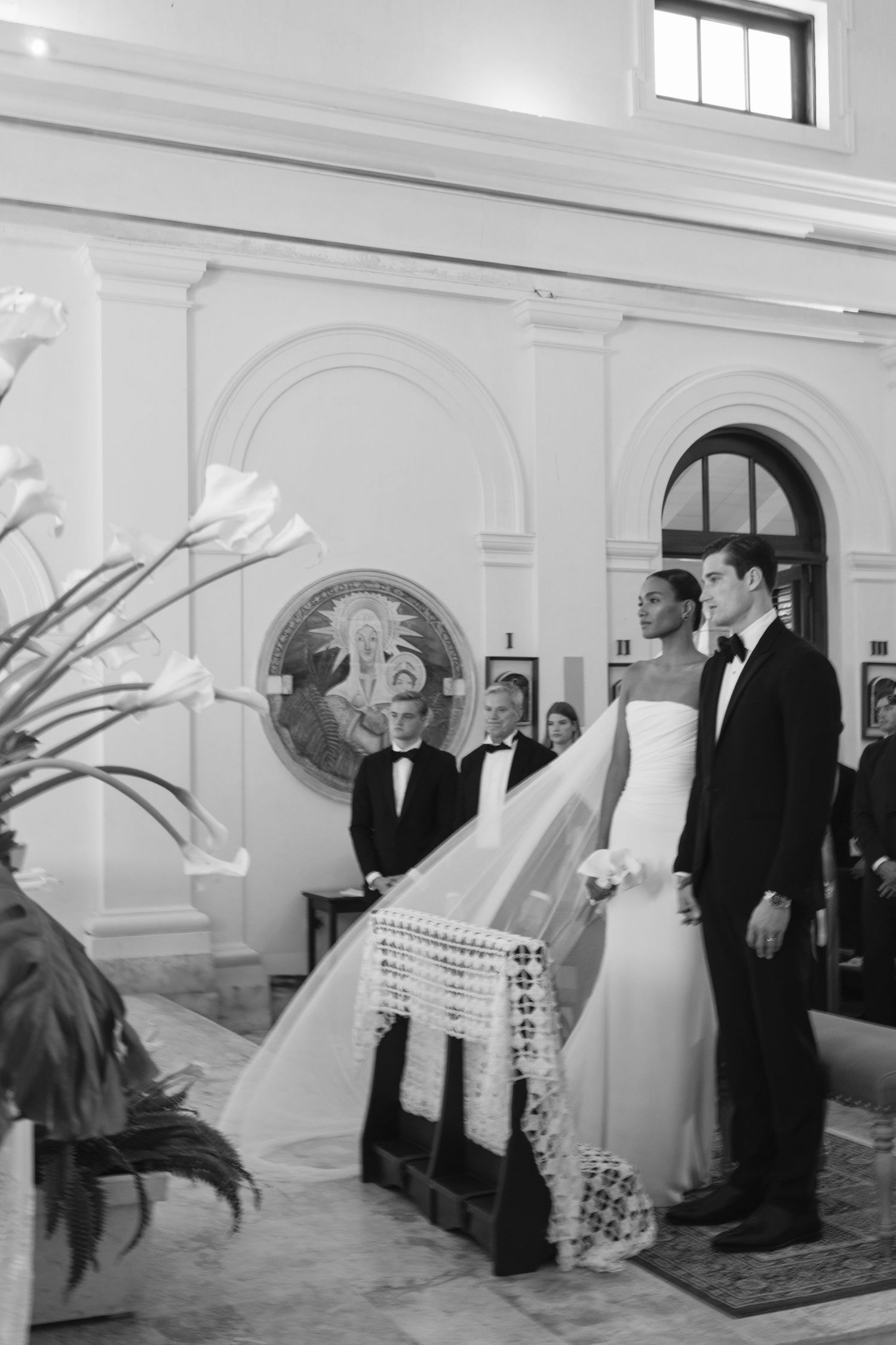 Classic black and white photograph of a wedding ceremony in a traditional church interior with elegant architecture.