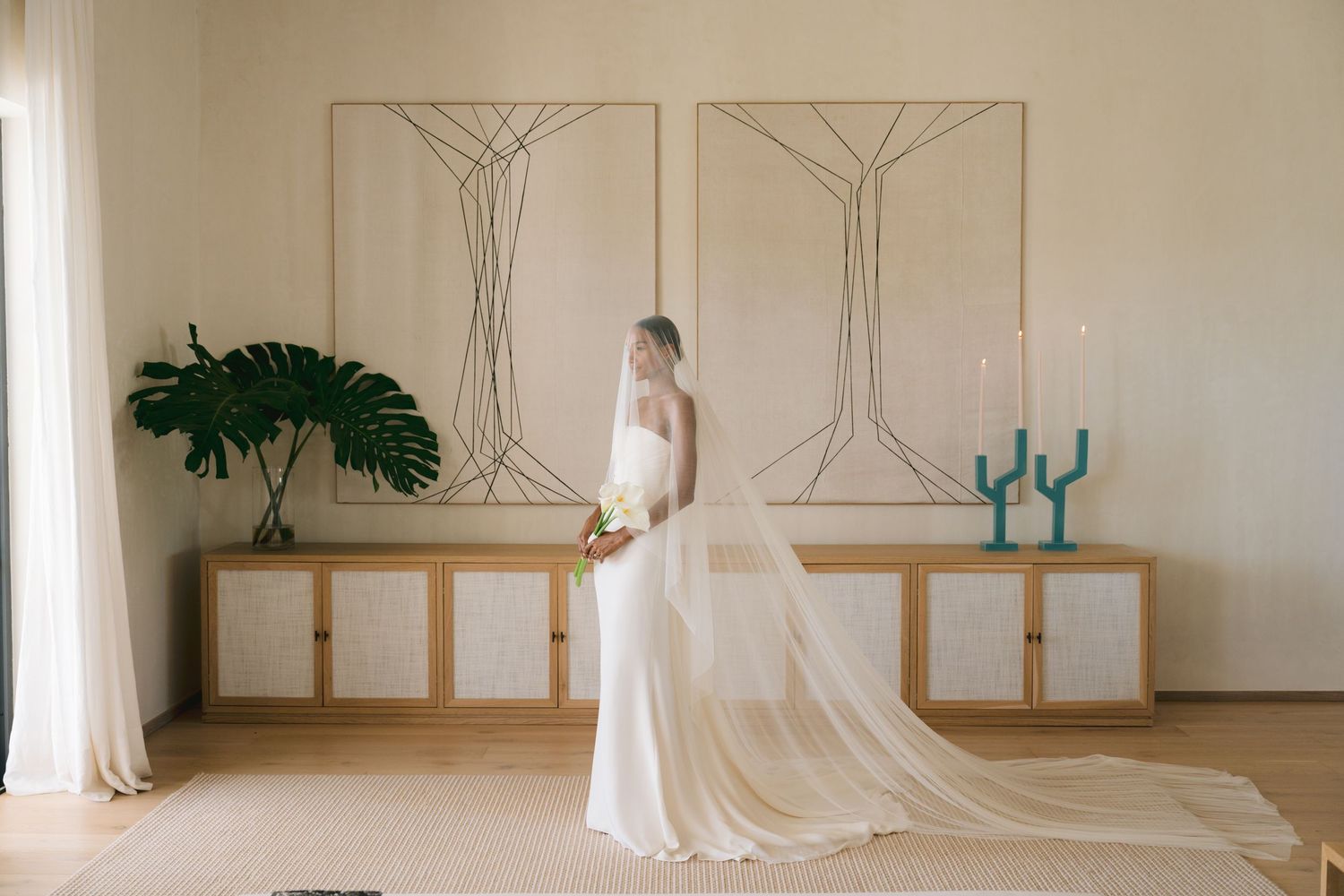 A elegant wedding dress shop interior with floating white gowns displayed along wooden racks against cream walls.