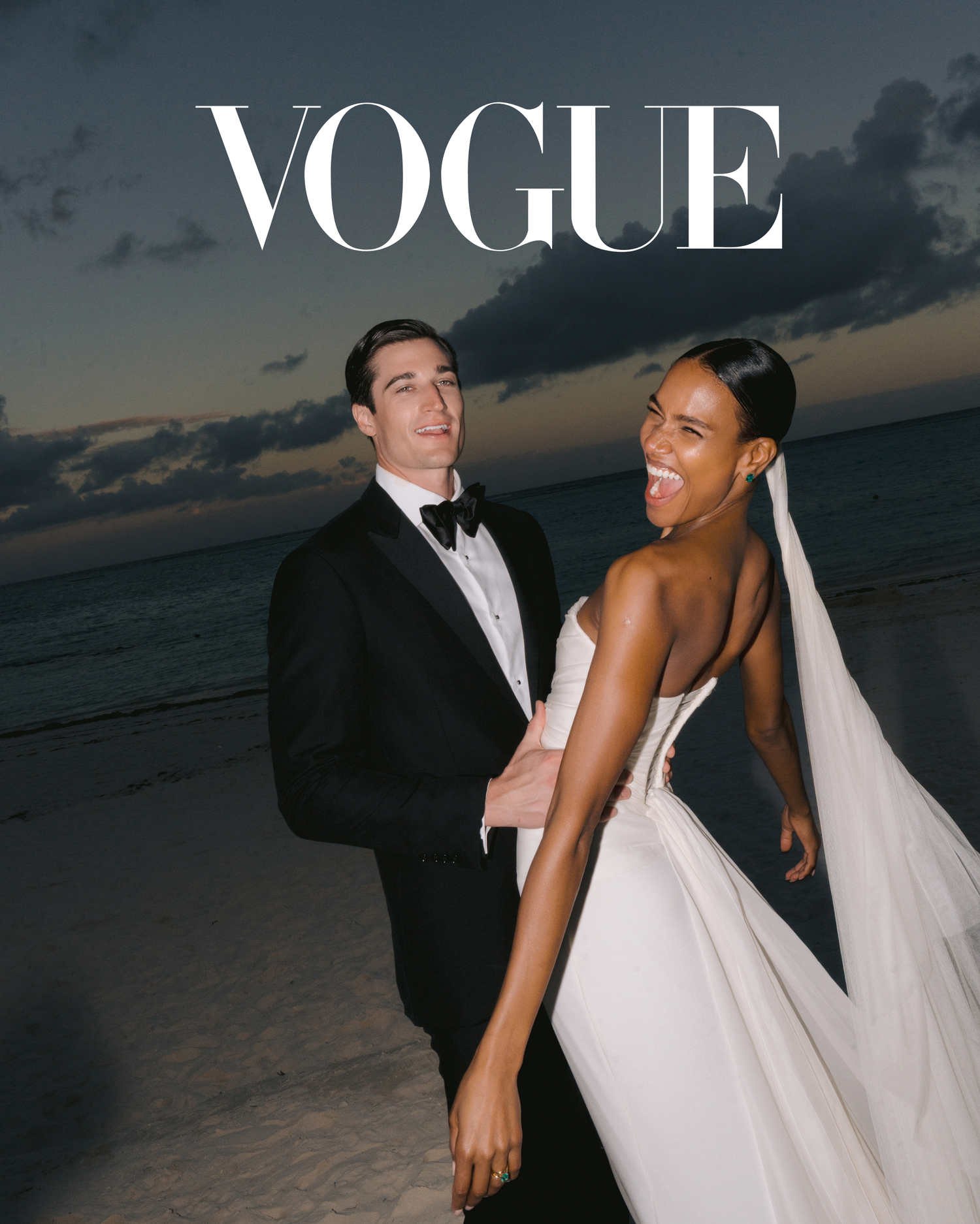Wedding couple laughs joyfully on beach at sunset with Vogue logo overhead in glamorous magazine-style photo.